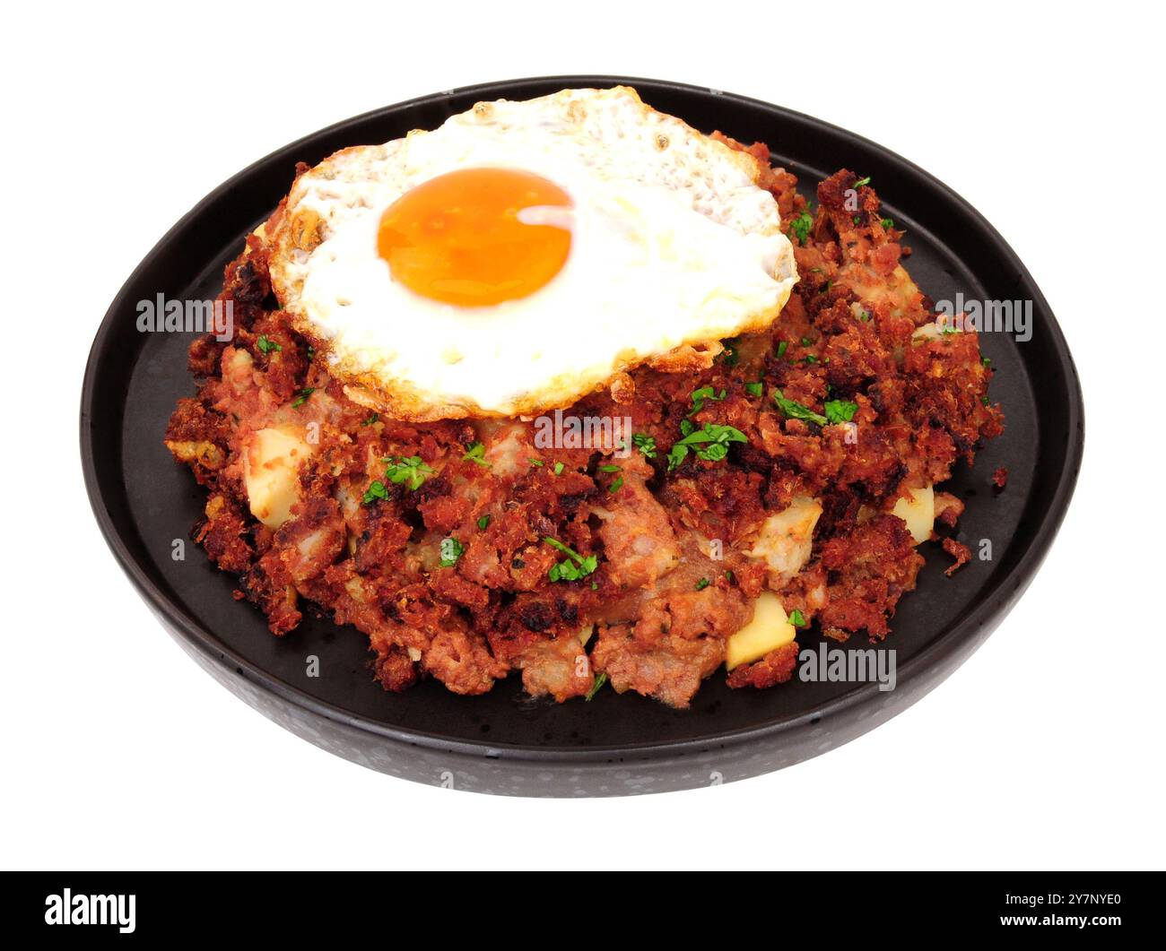 Traditionelles Corned Beef Hash Mahl mit einem Spiegelei isoliert auf weißem Hintergrund Stockfoto