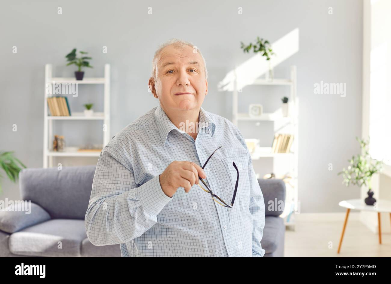Porträt eines gutaussehenden älteren, selbstbewussten, glücklichen, reifen Mannes zu Hause, der in die Kamera schaut Stockfoto