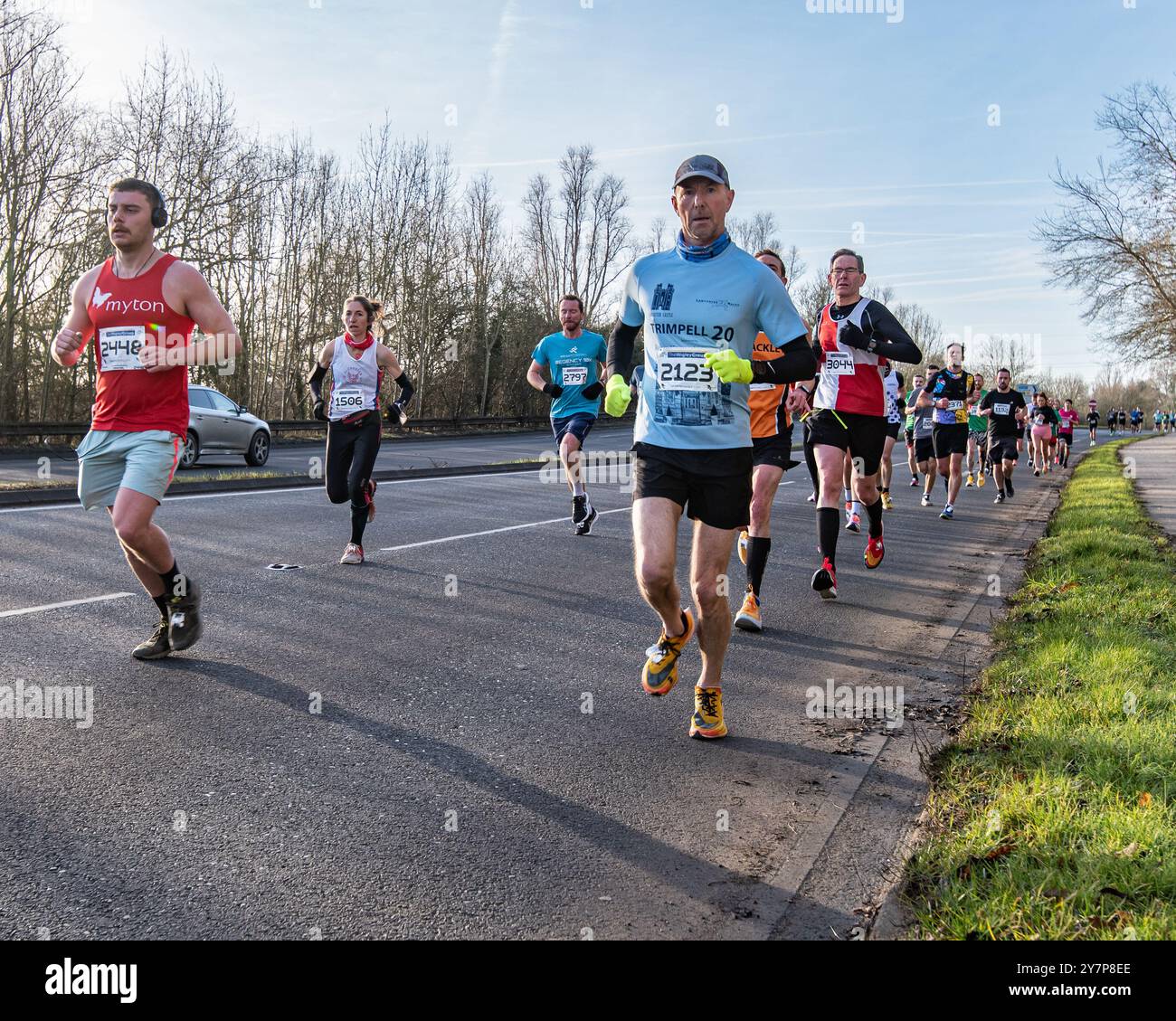 Läufer bei einem Straßenrennen lächeln und lachen in der hellen Frühlingssonne. Stockfoto