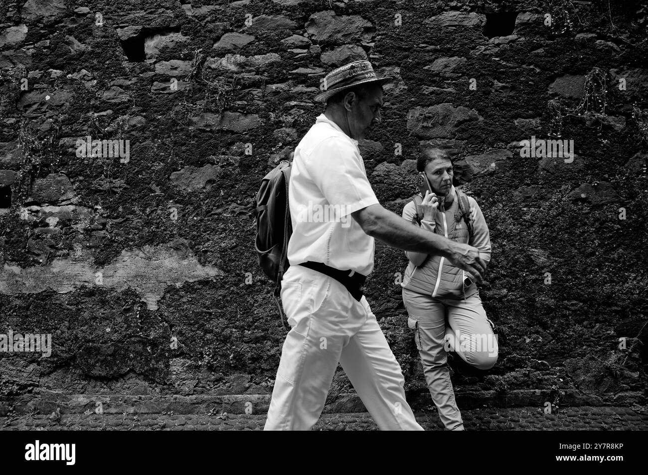 Ein fokussierter Carreiro läuft am Telefon an einem Touristen vorbei Stockfoto