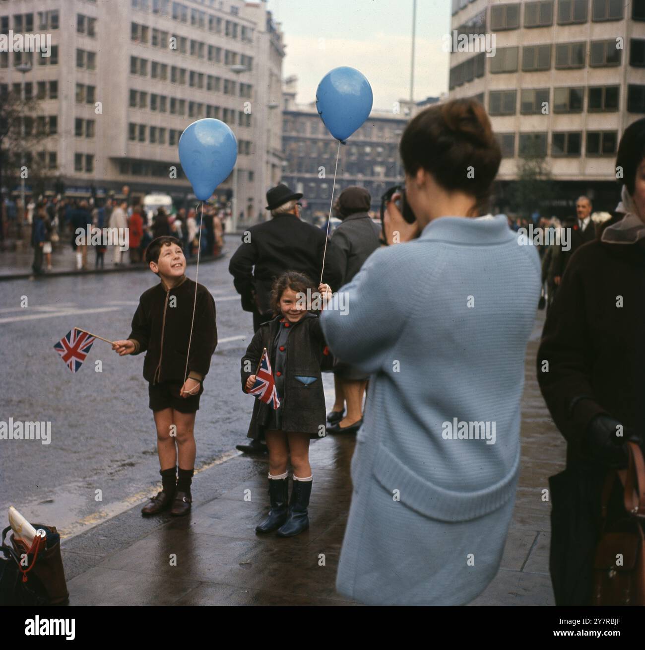 Eine Mutter fotografiert ihre Kinder bei der Straßenparade am Lord Mayor's Day in London, England, Großbritannien. Um die 1970er Jahre Stockfoto