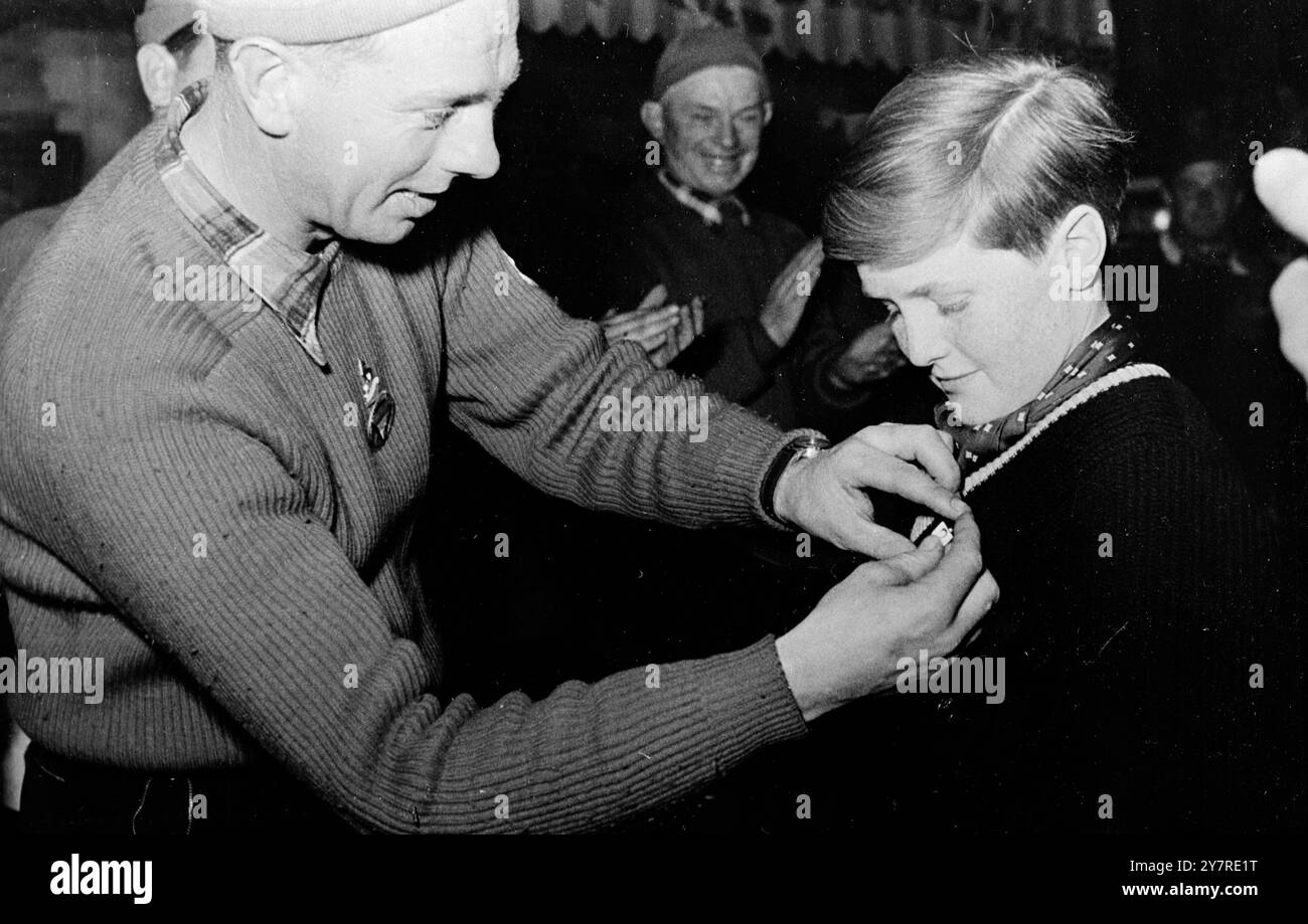 WINSTON CHURCHILL ENKEL BEKOMMT SKIDIPLOM. Winston Churchill, 12 Jahre alt, Enkel des britischen Premierministers Sir Winston Churchill, erhielt das Ski-Test-Diplom von seinem Skilehrer in Kitzbühel. Sein Lehrer beschrieb den Jungen als einen sehr mutigen jungen Mann, der noch härter wird, wenn es hart wird. Ein Skilehrer in Kitzbühel stemmt das „Skitest“-Diplom auf die Brust des 12-jährigen Winston Churchill. Stockfoto
