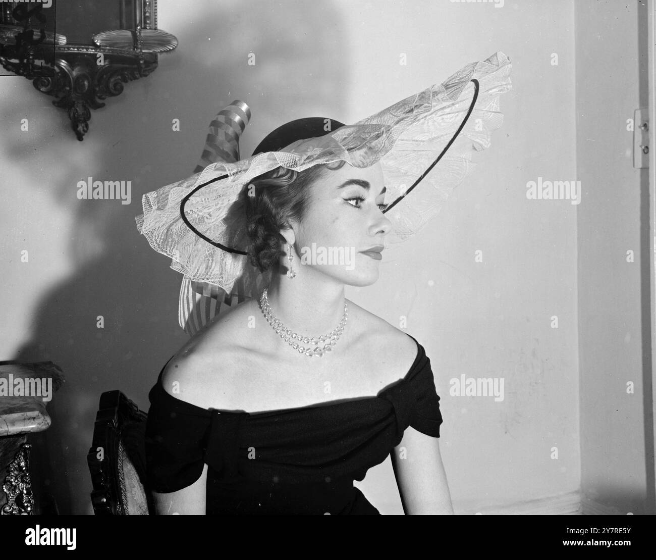 DENISE BESTEIGT DEN BANDWAGEN 7.1.54 Denise, Lady Newborough, nennt diesen Hut aus Spitze und schwarzem Samt „New Sun“. Es wurde von dem Film Band Wagon inspiriert und wird von Gillian Tait getragen. Bild von Reg Palmer PJ/73723 (24) Fotos von internationalen Nachrichten. Stockfoto