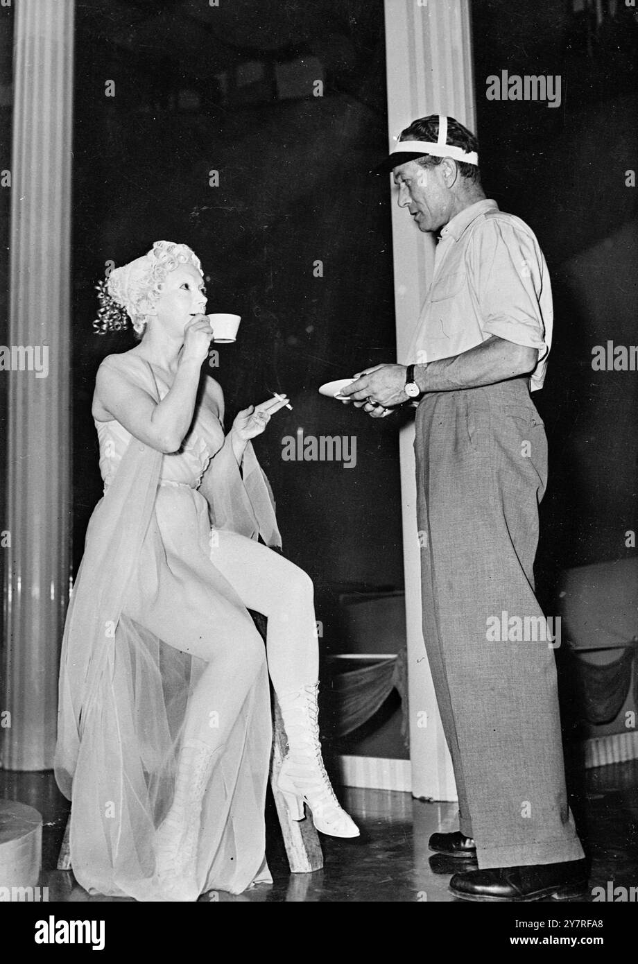 Die Statue nimmt sich Zeit für einen Kaffee. Das Leben eines Filmstars ist nie einfach, aber die Wiener Schauspielerin Gretl Schoerg findet es noch unbequemer als sonst in ihrem neuesten Film, in dem sie komplett mit einer Kalklösung bedeckt wurde, um sie in eine Statue zu verwandeln. Das INP-Foto zeigt sogar eine Statue kann sich nach Kaffee und Zigarette sehnen, wenn sie wirklich ein Mensch ist, und Gretl brauchte sie sicherlich, nachdem er den halben Morgen auf einem Podest posierte. 142/PJ/73400 International News Photos. Stockfoto