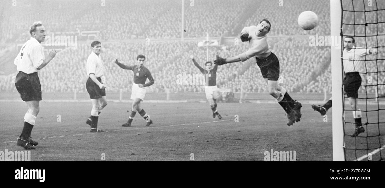 England gegen Ungarn in Wembley. Ungarn gewinnt mit 6:3. 25.11.53. England traf sich heute Nachmittag beim Fußball mit Ungarn, und zwei Rekorde standen auf dem Spiel. Ungarn hatte seit Mai 1950 25 Spiele ohne Niederlage gespielt, während England seinen einzigartigen Rekord verteidigte, nie im eigenen Land gegen eine ausländische Mannschaft verloren zu haben. Die Länder trafen sich zuletzt 1936 in London. Sie hatten sich zweimal gespielt und jeweils einen gewonnen. Das BIPPA-Foto zeigt Captain Wright (links) und A. Ramsey (im Netz), wie Merrick einen Schuss an der Post vorbeiführt. FO/CP/PJ/72945. Fotos Von Internationalen Nachrichten. Stockfoto