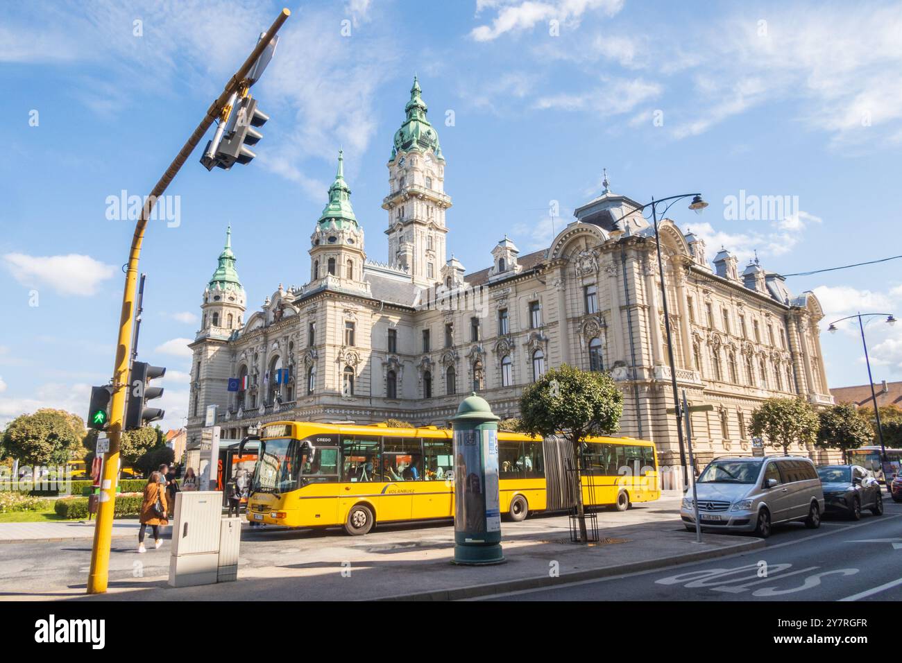Gyor, Ungarn - 25. September 2024: Rathaus und gelber Bus mit Leuten an der Bushaltestelle auf der Straße Stockfoto