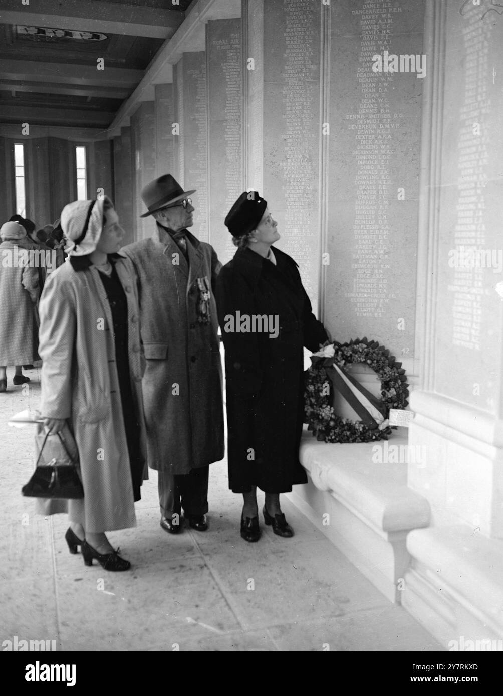 QUEEN ENTHÜLLT RUNNYMEDE MEMORIAL 17.10.53. M. die Königin hat heute Nachmittag das Runnymede-Denkmal für die 20.455 Flieger enthüllt, die im Krieg 1939-45 ihr Leben gaben und keine Gräber haben. Das von der Imperial war Graves Commission erbaute Denkmal besteht aus einem Kreuzgang, in dem die Namen der Männer auf Steinplatten und in einem gedruckten Register vermerkt sind, und einem gewölbten Schrein zur Besinnung. INP FOTOSHOWS: Menschenmengen von Verwandten sehen die Kränze nach der Zeremonie heute Nachmittag. Stockfoto