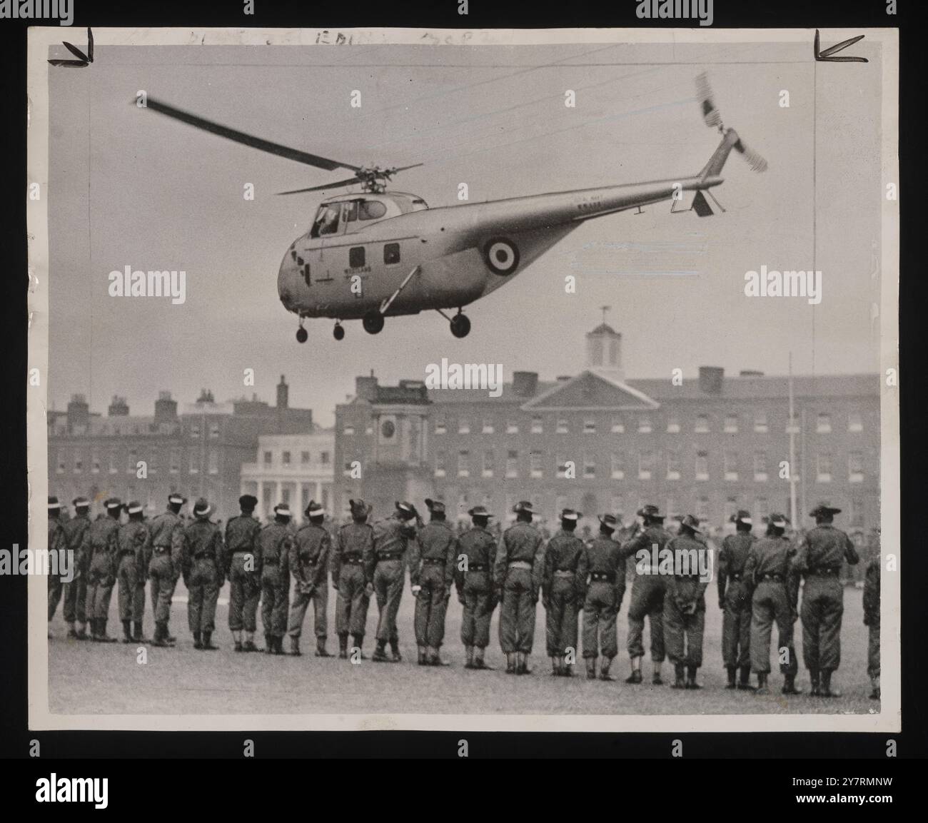 Sie sahen zu, wie der fliegende Duke abreiste. - London: Die Kolonialstreitkräfte stehen in der Reihe und beobachten, wie ein Hubschrauber mit dem Duke of Edinburgh von der Woolwich Barracks abhebt, nachdem er die Krönungstruppen dort inspiziert hat. Das Schwebeflugzeug, das der Duke am zweiten Tag in Folge benutzte, flog zurück zum Buckingham Palace, um auf dem Palastrasen zu landen, von wo es heute Morgen abgefeuert war. 27. Mai 1953. Planet News. Stockfoto