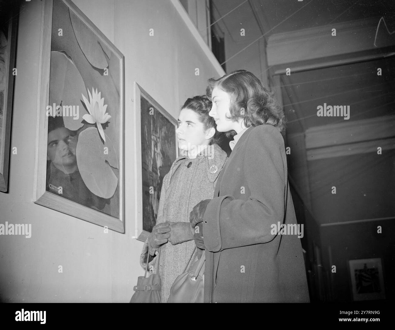 Zum ersten Mal wird das Publikum die Möglichkeit haben , eine 40-jährige Sammlung von Londoner Gemälden berühmter Künstler zu sehen , wenn der Prim Minister am 5 . April die Ausstellung " Art for All " im Victoria and Albert Museum in London eröffnet . Die Ausstellung wurde gemeinsam vom Museum und London Transport organisiert und zeigt Werke von zahlreichen berühmten Künstlern , die zwischen 1908 und heute Plakate für London Transport und seine Vorgänger gemalt haben . DAS BILD ZEIGT :- Londoner Kunststudenten BARBARA McEwen ( links ) und CATHALENE CHANEY, die Hampton Co. Ansehen Stockfoto