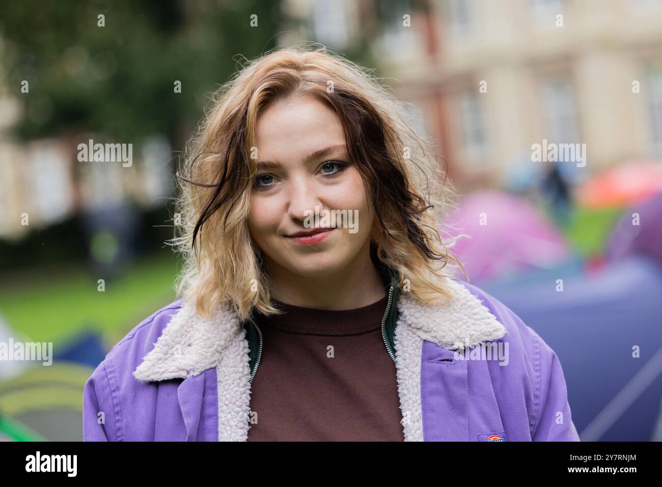 PRODUKTION - 01. Oktober 2024, Nordrhein-Westfalen, Münster: Bineta Hansen (Studentin Kim Moser), Schauspielerin, steht zwischen Zelten im Park hinter der Burg am Set des Münsterer Tatorts. Die neue Episode „Ich gestehe“ (AT) befasst sich mit dem Wohnungsmangel bei Studenten. Foto: Rolf Vennenbernd/dpa Stockfoto