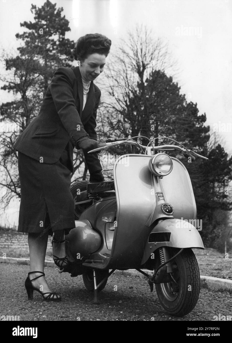 BEQUEM UNTERWEGS – Männer und Frauen, die eine robuste Halterung für geschäftliche oder private Zwecke suchen, werden das Auftauchen eines neuartigen und vielseitigen persönlichen Transportmittels in Großbritannien begrüßen: Das Douglas Vespa Zweiradfahrzeug. Als Nachbildung der italienischen Vespa beginnt das neue Modell am 15. März von den Produktionslinien hier aus zu Rollen. Er wird von einem 125-c.c.-Zweitaktmotor angetrieben, der ihn mit einer konstanten Geschwindigkeit von 45 km/h antreibt. Eine Attraktion für die Hausfrau oder professionelle Fahrerin ist das Design, das viel Beinfreiheit bietet. Der Fahrer muss nicht auf dem Tank oder Motor sitzen. Und A Stockfoto