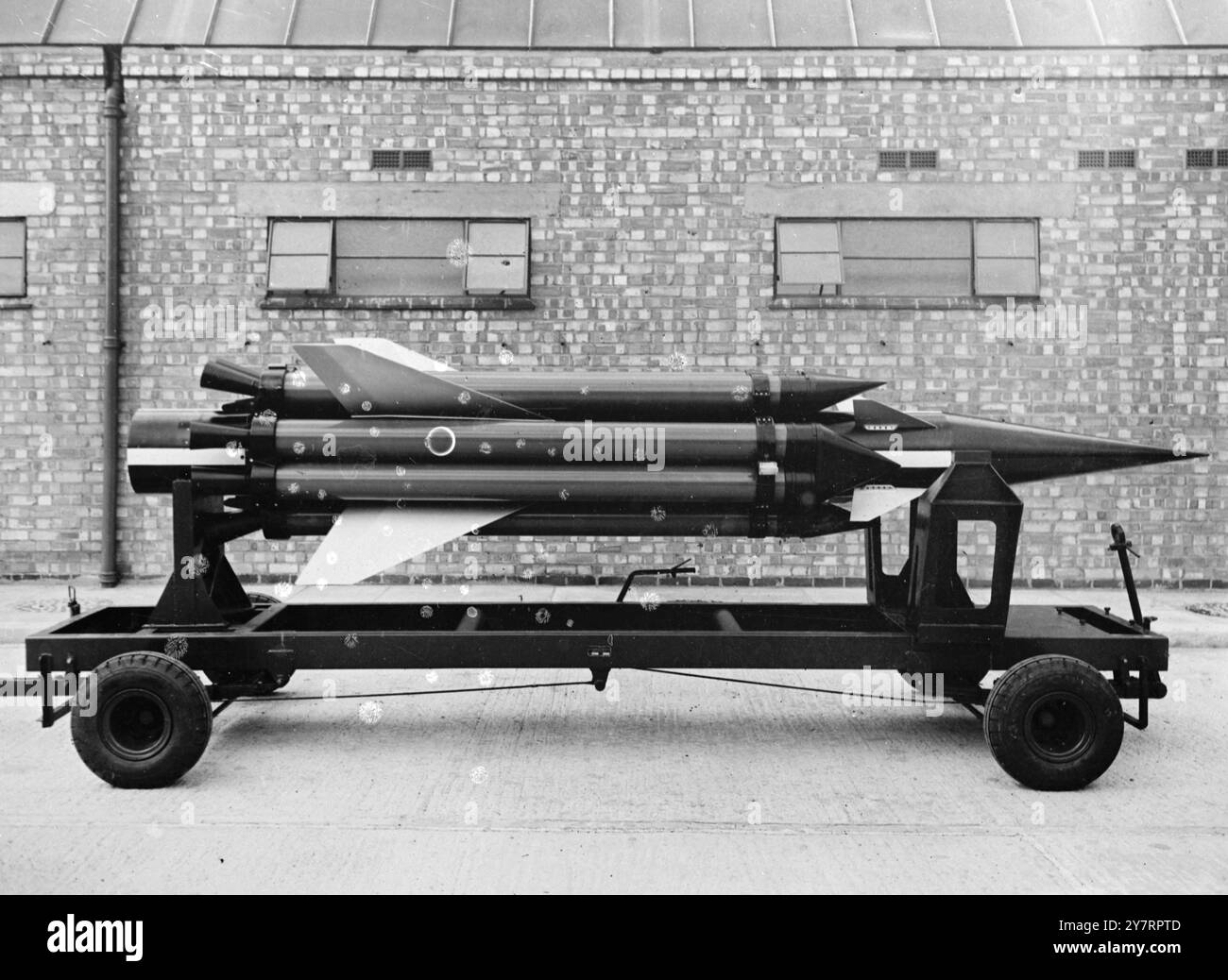 ERSTES VERÖFFENTLICHTES BILD VON - BRITISCHER LENKRAKETE - 4,9.53. - Geführte Raketen, die feindlichen Flugzeugen folgen können, bis sie in Reichweite sind und dann explodieren, sind jetzt perfektioniert worden. - Das I.N.P. Foto zeigt ein früheres Armstrong Whitworth-Raketentestfahrzeug. Herr H. M. Woodhams, 2 Geschäftsführer, verweist auf die Hilfsraketen, die dem Hauptfahrzeug helfen, seine Überschallgeschwindigkeit zu beschleunigen. - 23/PJ/70@2,8 - Fotos von internationalen Nachrichten Stockfoto