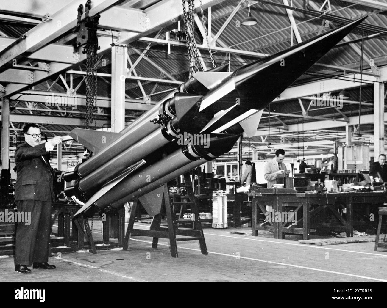 ERSTES VERÖFFENTLICHTES BILD VON - BRITISCHER LENKRAKETE - 4,9.53. - Geführte Raketen, die feindlichen Flugzeugen folgen können, bis sie in Reichweite sind und dann explodieren, sind jetzt perfektioniert worden. - Das I.N.P. Foto zeigt ein früheres Armstrong Whitworth-Raketentestfahrzeug. Herr H. M. Woodhams, 2 Geschäftsführer, verweist auf die Hilfsraketen, die dem Hauptfahrzeug helfen, seine Überschallgeschwindigkeit zu beschleunigen. - 23/PJ/70@2,8 - Fotos von internationalen Nachrichten Stockfoto