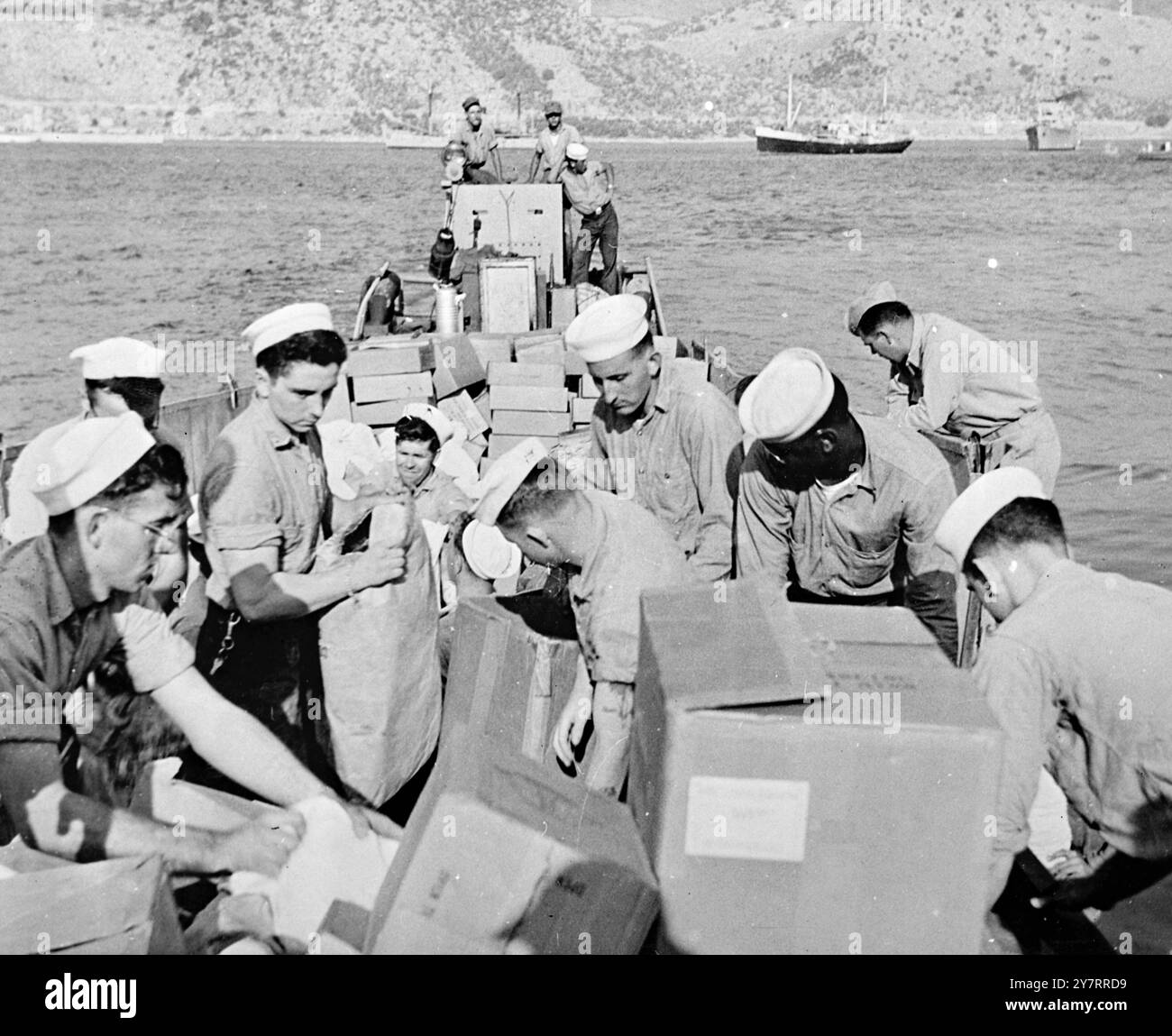 HILFSGÜTER FÜR GRIECHISCHE ERDBEBENOPFER - 19.8,53. - Aus allen Teilen der Welt Nahrungsmittel, Kleidung und medizinische Versorgungsgüter, die für die Opfer der - Erdküsse auf den Ionismus-Inseln nach Griechenland gebracht werden. - 24. Das Foto zeigt Seeleute von Franklin D. Roosevelt entlädt die Vorräte in Cephallonia. - 4/PJ/70649 - Internationale Nachrichten Photoa Stockfoto