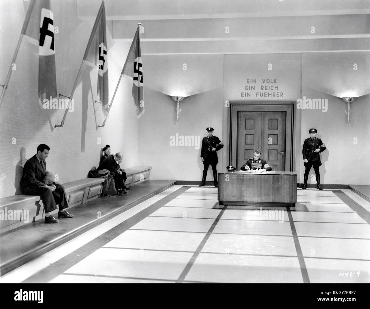 ROBERT TAYLOR sitzt im Wartezimmer des Büros in Nazi-Deutschland in ESCAPE 1940 Regisseur MERVYN Leroy Roman Ethel Vance Art Direction Cedric Gibbons Associate Art Director Urie McCleary Set Dekoration Edwin B. Willis und Jack D. Moore (unkreditiert) Metro Goldwyn Mayer (MGM) Stockfoto