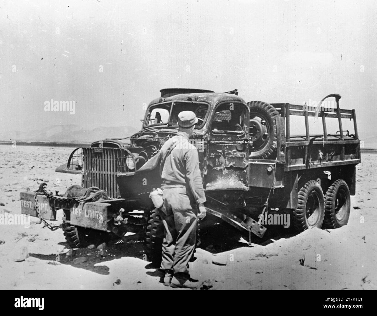 ARMEEWAGEN WURDE VON EINER BOMBENEXPLOSION ..... ANGEGRIFFEN Las Vegas, Nevada... Ein nicht identifizierter Soldat wird gezeigt, wie er einen eineinhalb Tonnen schweren Wagen der Armee inspiziert, der zwischen 400 und 500 Jahren vom Boden Null der Atombombenexplosion in Yucca Flat, Nevada, USA, letzten Dienstag entfernt war. 24. April 1952 Stockfoto
