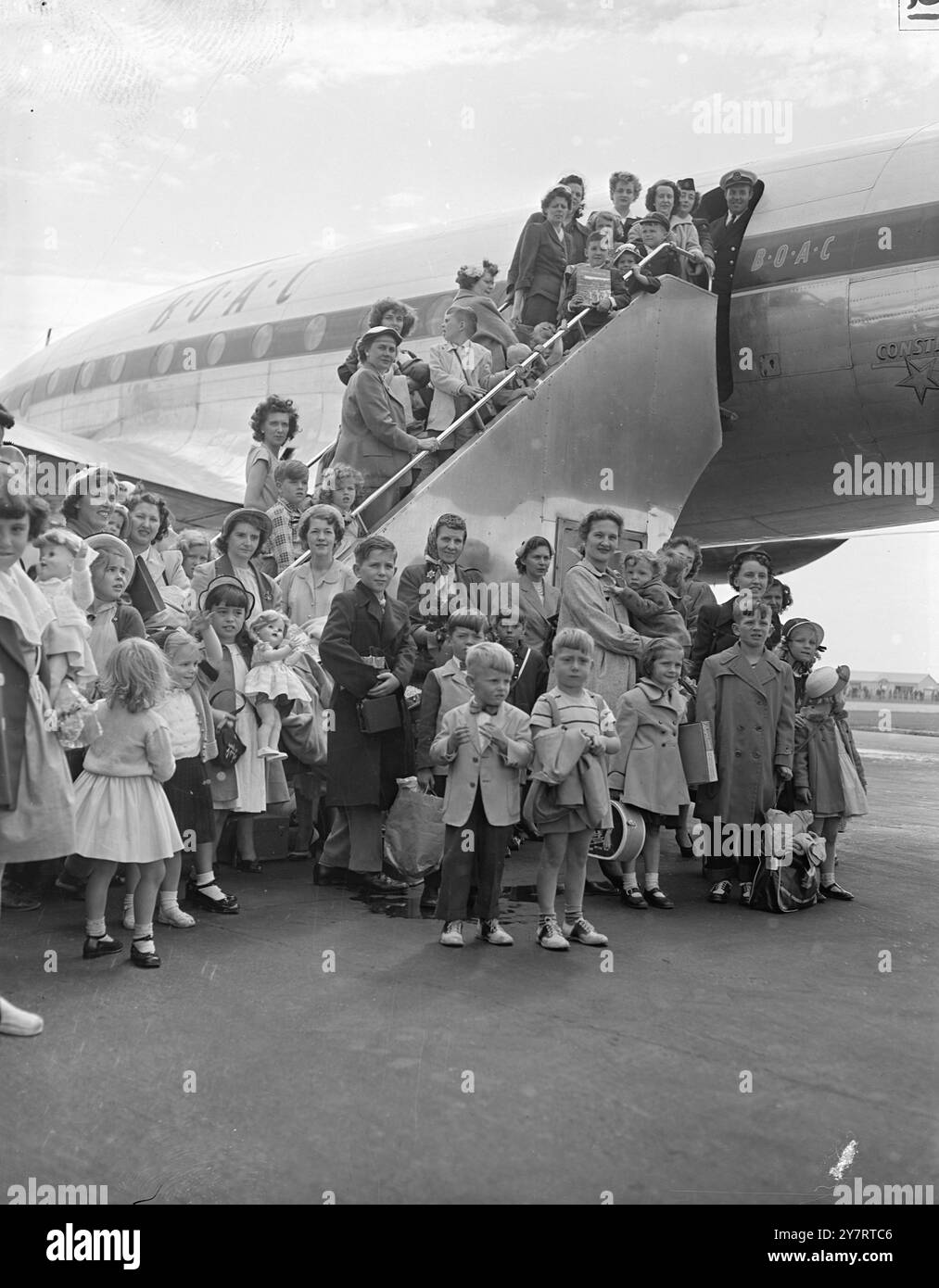 KRIEGSBRÄUTE FLIEGEN UM 7,53 UHR ZURÜCK. Die dritte Partei, die von einer American war Brides’ Association organisiert wurde und in diesem Jahr Großbritannien besucht hat, flog heute vom Flughafen London in die Vereinigten Staaten zurück. Die Vereinigung, die von Judy Bond aus Ridgewood, New Jersey, organisiert wird, hat 500 Mitglieder, die 20 Kapiteln in ganz Amerika angehören. FOTOSHOWS: Nach 3 Monaten in die Heimat reisen 26 GI Brides und ihre 42 Kinder auf den Stufen des speziellen BOAC Stratocruiser, der sie zurück in die Vereinigten Staaten flog. 21. Juli 1953 Stockfoto