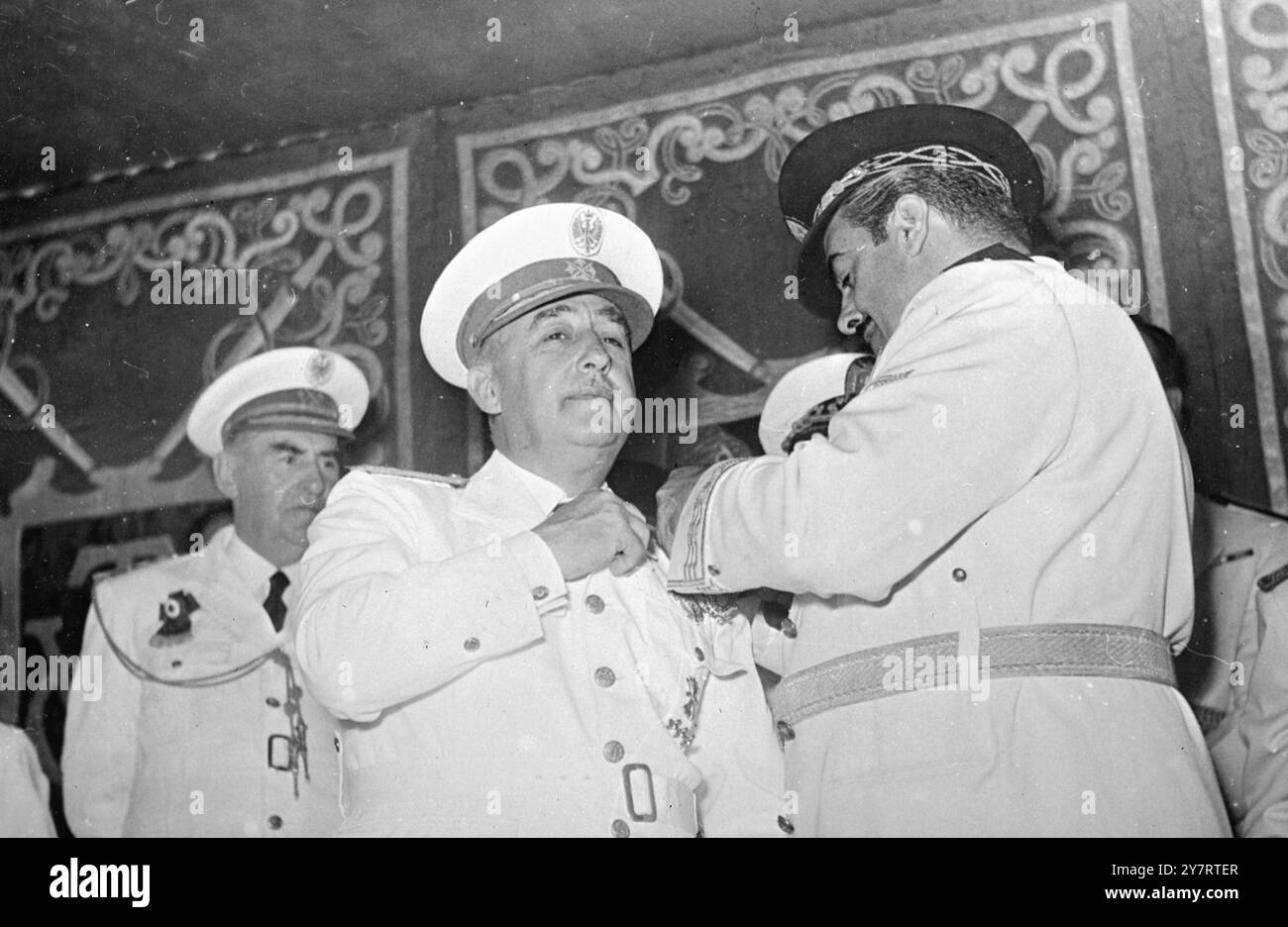 FRANCO IST DEKORIERT 20.7,53. Spanien feierte letzte Woche den 17. Jahrestag des Aufstands gegen die Republik. Foto zeigt Arbeitsminister Jose Antonio Giron (rechts), schmückt Generalissimo Franco in einer Zeremonie im El Pardo Palace, Madrid, Spanien, mit der einzigen Goldmedaille des Werks. 20. Juli 1953 Stockfoto