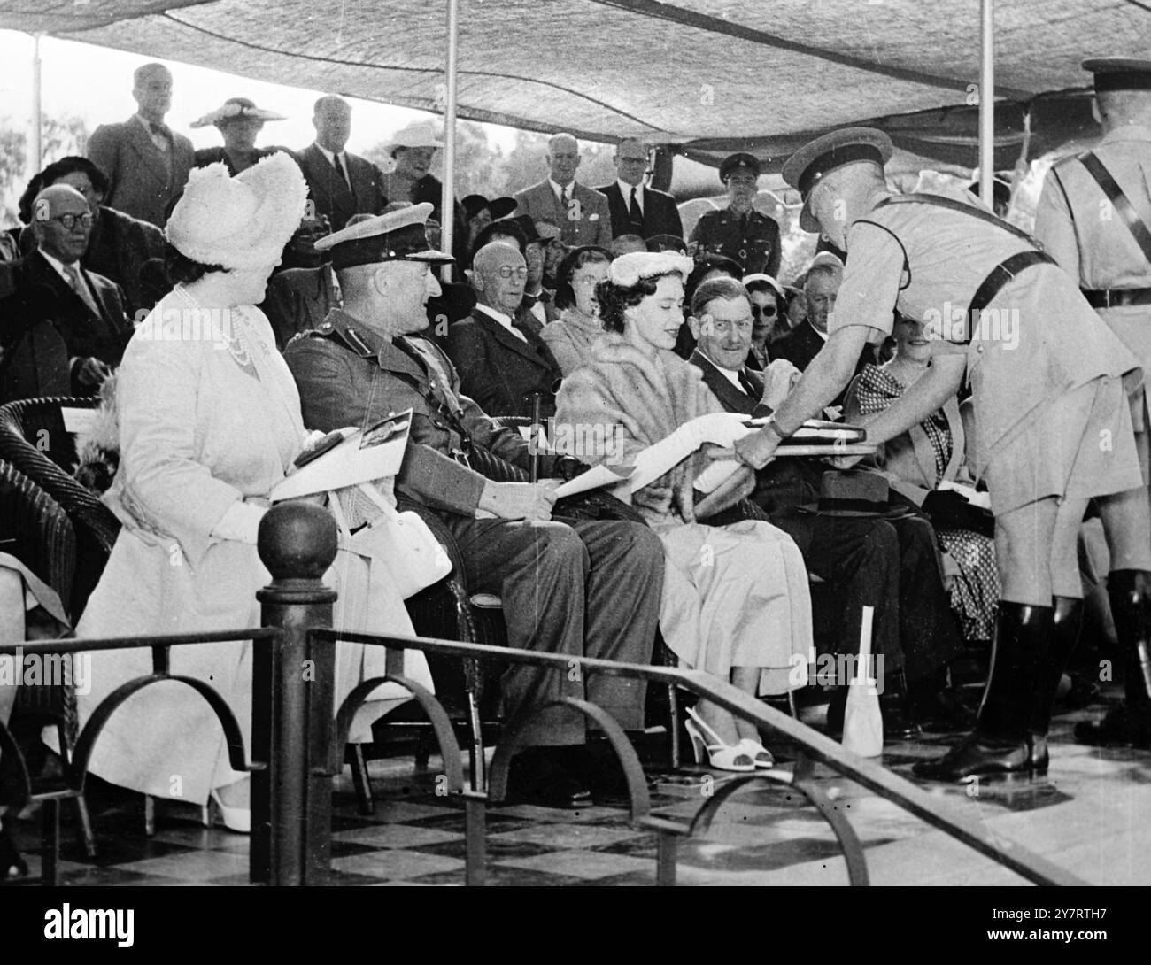 KÖNIGIN MUTTER UND PRINZESSIN BEI DER POLIZEIAUSSTELLUNG 16.7,53. Prinzessin Margaret erhielt eine Kopie des Buches „Blue and Old Gold“, als sie die Queen Mother am vergangenen Montag zu einer Ausstellung der Britischen Südafrikanischen Polizei in Salisbury, Südrhodesien, begleitete. Foto zeigt Brigadier J. Appleby, Commissioner of Police, sitzt zwischen der Königin Mutter und Prinzessin Margaret, während das Buch präsentiert wird. 16. Juli 1953 Stockfoto