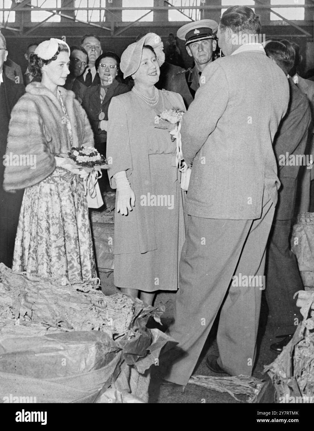 KÖNIGIN MUTTER UND PRINZESSIN MARGARET BEI DER TABAKAUKTION. 15.7,53. Königin Elizabeth, die Königin Mutter und Prinzessin Margaret besuchten heute die Verkaufsauktion der Tabakproduzenten in Salibury, Südrhodesien. FOTOSHOWS. Prinzessin Margaret hört zu, wie die Queen Mother mit dem Auktionator Mr. Z.E. Edwards aus Greenville, North Carolina, USA, plaudert, als sie die Tabakauktion besuchten. 15. Juli 1953 Stockfoto