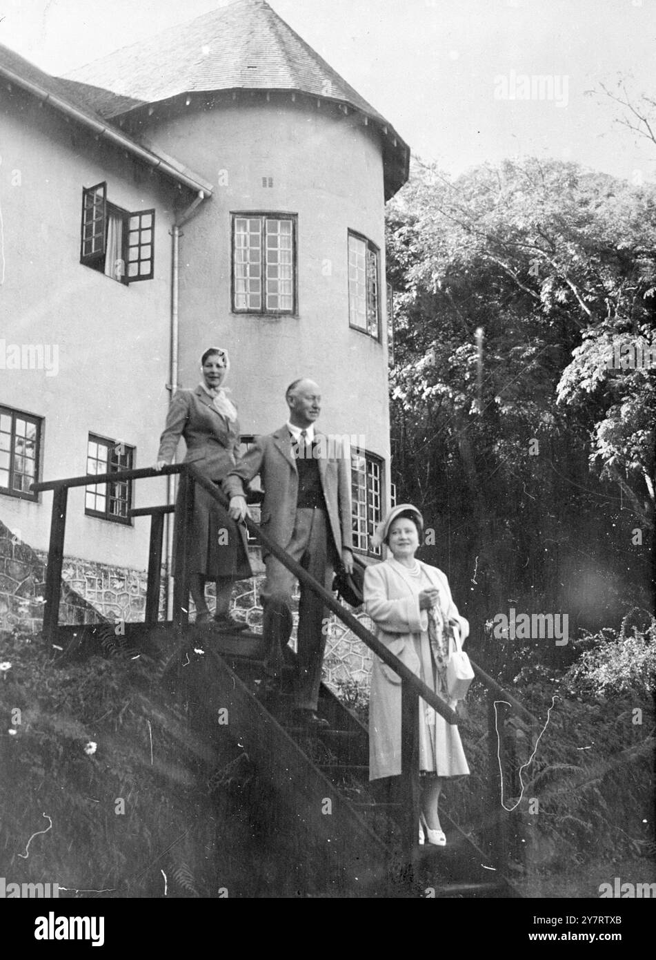 KÖNIGLICHE REISE NACH RHODESIEN 12.7,53. H.M. die Königin Mutter besuchte das Leopard Rock Hotel in den Vumba Mountains. Prinzessin Margaret kam wegen einer Erkältung nicht auf Fotos. FOTOSHOWS: Die Königin Mutter mit dem Gouverneur von Südrhodesien und Lady Kennedy, die die Stufen des Hotels hinunter auf den Rasen vor dem Hotel steigen. 12. Juli 1953 Stockfoto