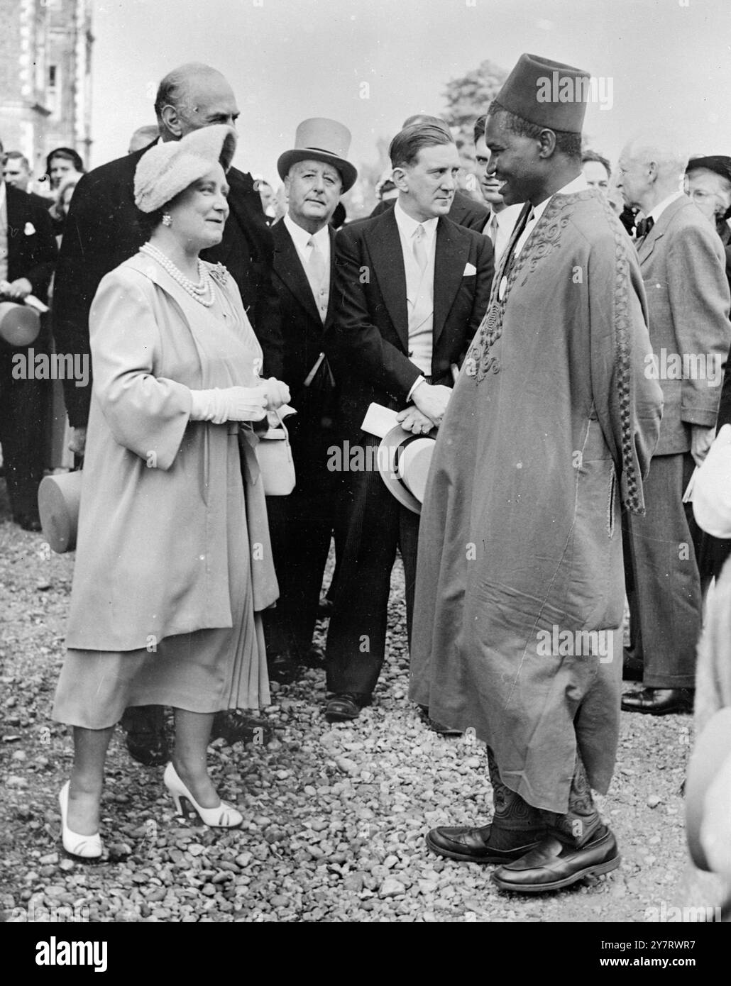 Königin Elizabeth, die Königin Mutter unterhält sich mit dem roten fes-gekrönten Mallam i Kaita von Nigeria während der THC-Gartenparty im Hatfield House , Hatfield , Hertfordshire am 31. Mai 1953 für Kolonialbesucher in England zur Krönung. Hatfield House ist das Zuhause des Duke of Salisbury31. Mai 1953 Stockfoto