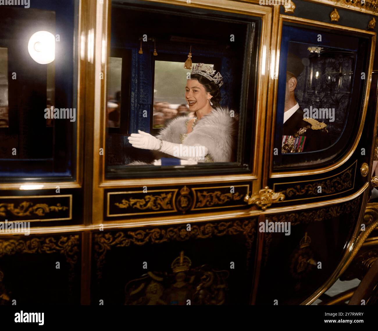 4. November 1952 London: Queen Elizabeth winkt mit ihrer linken Hand den Menschenmassen vom Irish State Coach zu, während sie mit dem Duke of Edinburgh durch die Horse Guards Parade zum House of Lords fährt, um das Parlament zu öffnen. Dies war das erste Mal, dass eine Königin seit 1886 das Parlament eröffnete. Fotografiert von Charles Dawson. Stockfoto