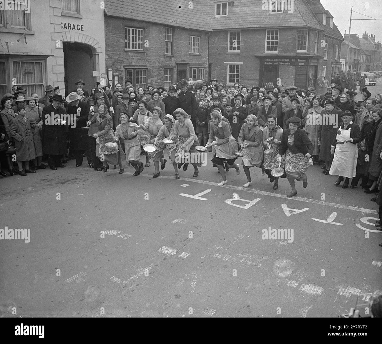 JUNGE MUTTER GEWINNT ENGLANDS PFANNKUCHENRENNEN IM ZWEITEN JAHR - HAT SIE AMERIKANISCHE RIVALEN BESIEGT? Das Pancake-Rennen für Hausfrauen in Olney, Buckinghamshire, England, das auf das Jahr 1445 zurückgeht, wurde heute zum zweiten Mal in Folge von der in Irland geborenen Mrs. Isabel Dix, 23, Mutter eines zwei Monate alten Babys, gewonnen. Ihre Zeit war 1 Minute 10,8 Sekunden für den 415-Yard-Kurs von der Dorfpumpe zur Kirche - mehr als zwei Sekunden schneller als letztes Jahr. Das Rennen wurde vor drei Jahren zu einer internationalen Veranstaltung. Das Ergebnis des heutigen Rennens in Liberal, Kansas, USA, wird nun erwartet, um zu sehen, ob die Frauen von Olney ihren Schritt gehalten haben Stockfoto