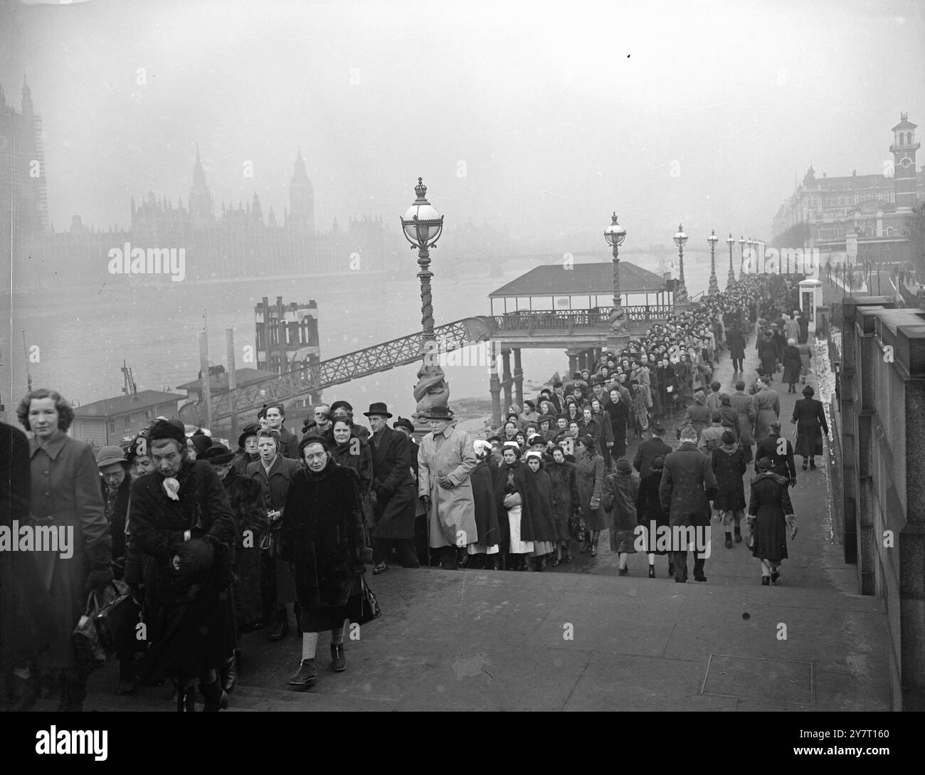 DIE HULDIGUNGSWARTESCHLANGE ERSTRECKT SICH ÜBER MEILEN 13-2-52 die große Warteschlange von Leuten, die warten, an der Katalk in Londons Westminster Hall vorbei zu landen, wo König George VI. Ist. In Zustand liegend, erstreckt sich jetzt über Meilen, es ist sechs und in einigen Teilen 10 tief. Es beginnt an der Großen Halle von Westminster selbst, geht direkt entlang einer Flussseite zur Lambeth Bridge, der Brücke und zurück auf der anderen Seite wieder zur Westminster BridgePHOTO ZEIGT:- die Warteschlange auf der gegenüberliegenden Flussseite bis Westminster, die sich in der Entfernung hinter St. Thomas's Hospital bis zur Westminster Bridge erstreckt. Westminst Stockfoto