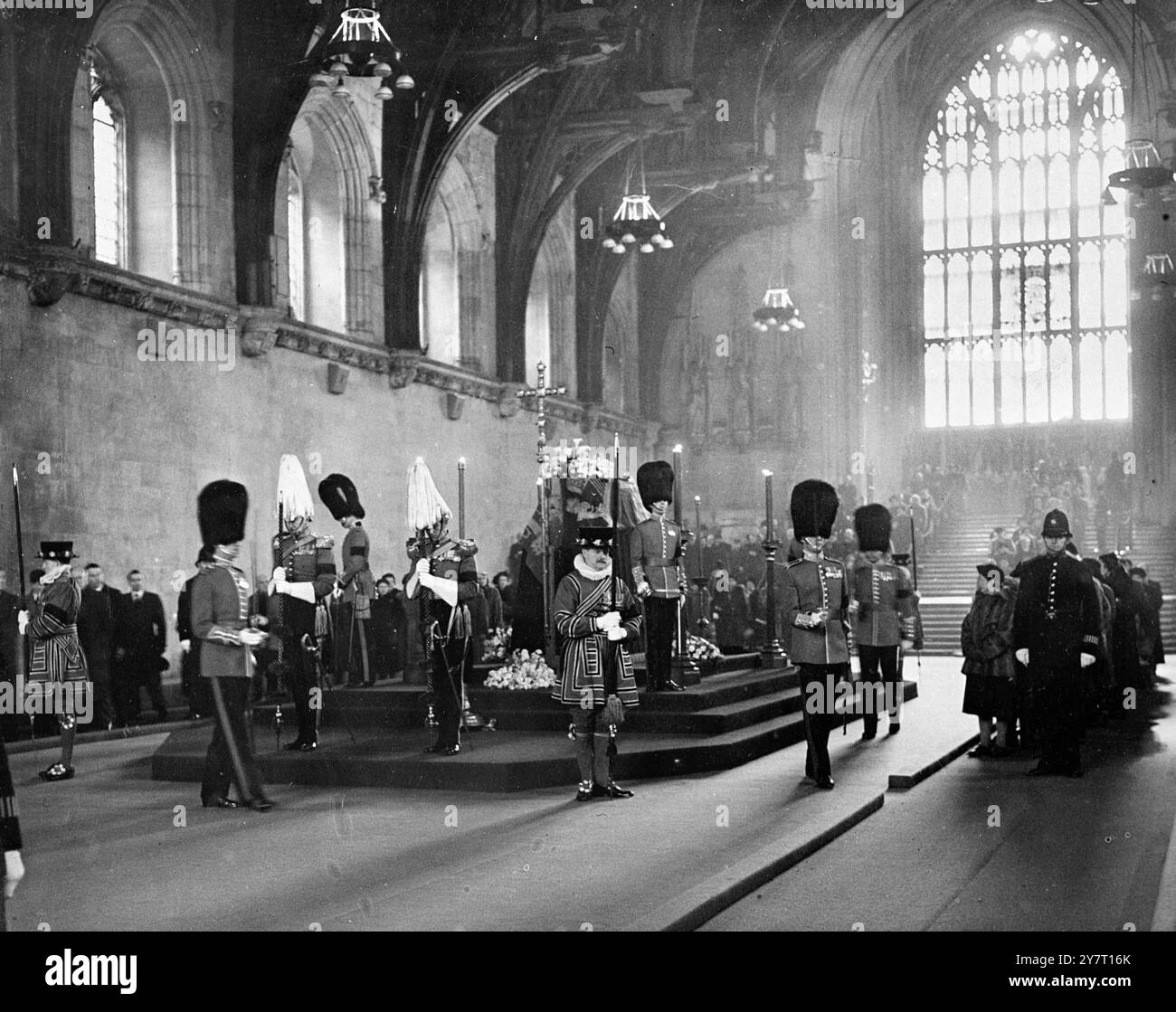 Die stillen Wächter wechseln die Wache, während die Menschen ihre Souveränität überqueren. Heute ist die beeindruckende Szene in der Great Hall of Westminster, London. Die Massen halten sich weiter an der Biere von König Georg VI. Vorbei, aber die Trauerkolonne rechts vom Bild wurde für einen kurzen Moment während der wechselnden Garde der Stille Wächter gestoppt. Die Grenadiergarde übernahm die Haushaltskavallerie. Wie alle Umstellungen während der Staatsliegenschaft wurde die Zeremonie in wahrer militärischer Präzision durchgeführt, aber absolut still. Es gab nicht einmal das Klappern eines Schwertes und es gab kein Stockfoto