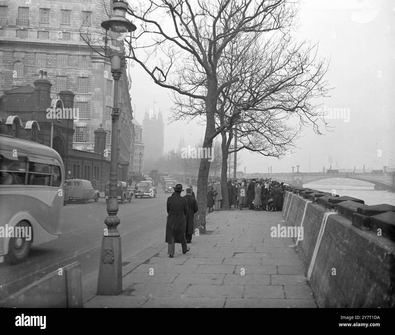 DIE LANGE WARTESCHLANGE, DIE ZU ZAHLEN ist, HOMMAGE AN IHREN KÖNIG 12-2-52 Tausende und Tausende von Menschen haben bereits seine verstorbene Majestät König George V1 geehrt, der in Londons hostorischer Westminster Hall liegt. Die Warteschlange begann sich über Nacht zu bilden. Und heute haben 4.000 Leute pro Stunde an der Katafalke vorbeigezogen. DAS I.N.P. FOTO ZEIGT: Die lange Schlange kurz vor der Dämmerung heute Abend, als die Schlange, sieben oder acht tief, sich fast eine halbe Meile lang erstreckte. Das war das Ende der Warteschlange - weit hinter der Lambeth Bridge. Als Büros, Geschäfte und Fabriken geschlossen wurden, schlossen sich immer mehr Menschen an Stockfoto