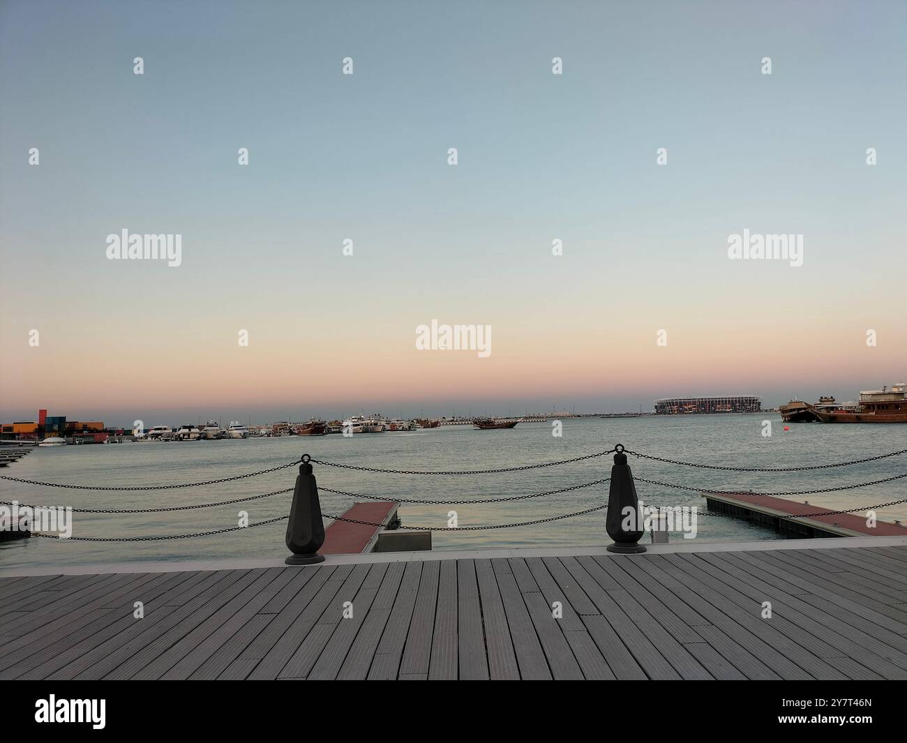 Goldener Sonnenuntergang über dem alten Hafen mit hölzerner Promenade Stockfoto