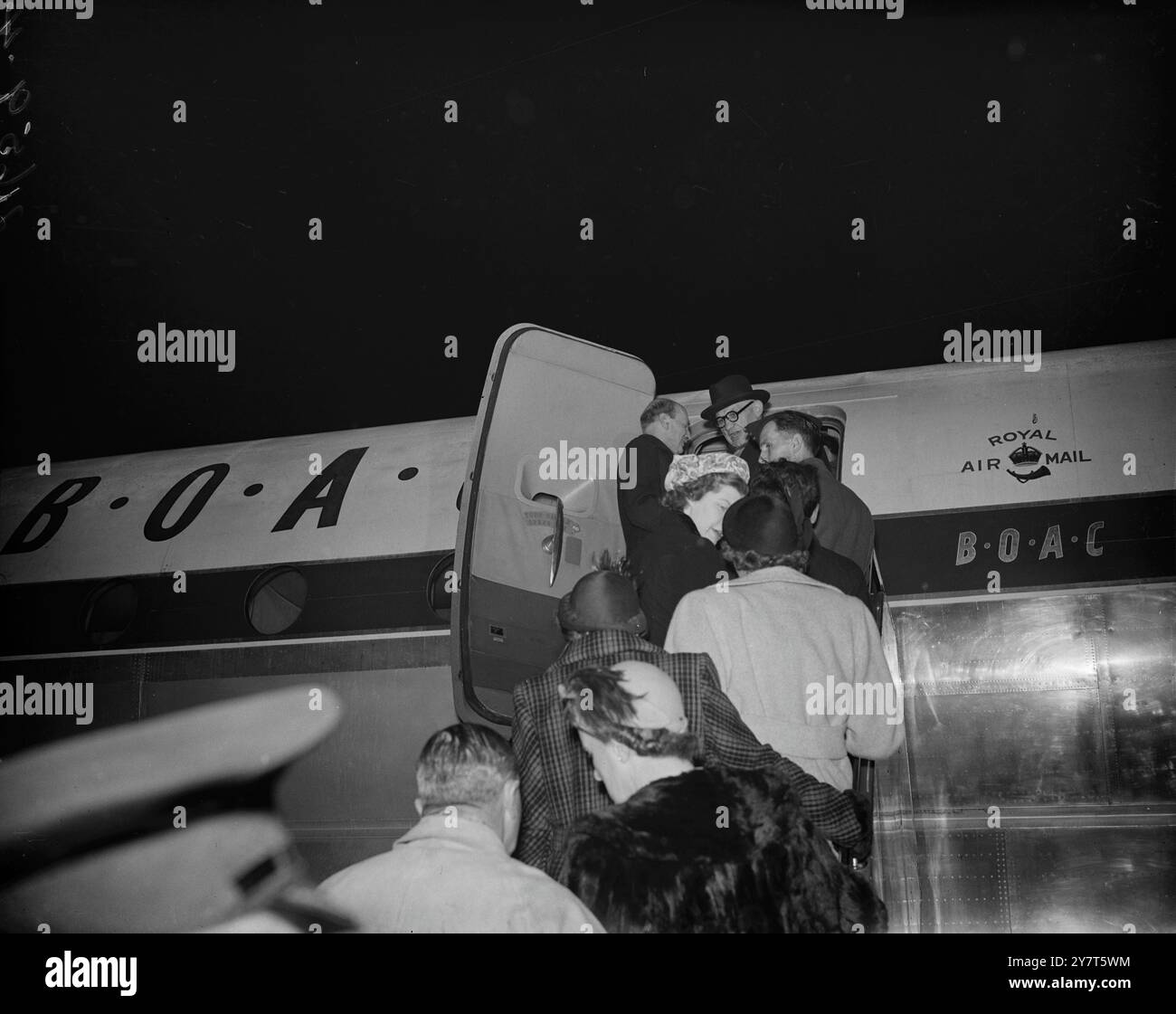 C.I.G.S. REIST MIT ATLEE NACH AMERIKA mit einem Zweig Heather in seinem Knopfloch, um Glück zu haben. Premierminister Clement Attlee, zusammen mit dem Chef des Kaiserlichen Generalstabs, Sir William Slim, bestieg heute Abend einen speziellen B.O.A.C. Stratocruiser am Londoner Flughafen, der nach Washington fährt. Herr Attlee wird mit Präsident Truman über die Außenpolitik und die kritische Lage im Koreakrieg sprechen. DAS BILD ZEIGT: Der Premierminister Attlee und seine Gefolgsleute besteigen das Flugzeug zu ihrem Treffen mit Präsident Truman in Washington. 3. Dezember 1950 Stockfoto