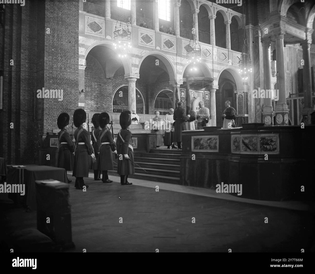 IRISCHE WACHEN MARSCHIEREN ZUR WESTMINSTER CATHEDRAL in der Westminster Cathedral in London heute als Administrator erhielt Pfarrer Monsignore Canon Collingwood von einem Offizier die alten Farben des 1. Bataillons Irish Guards, die in der Kathedrale zur Verwahrung gelegt wurden, bis sie in die Guards Chapel gebracht werden konnten. 12. Dezember 1950 Stockfoto