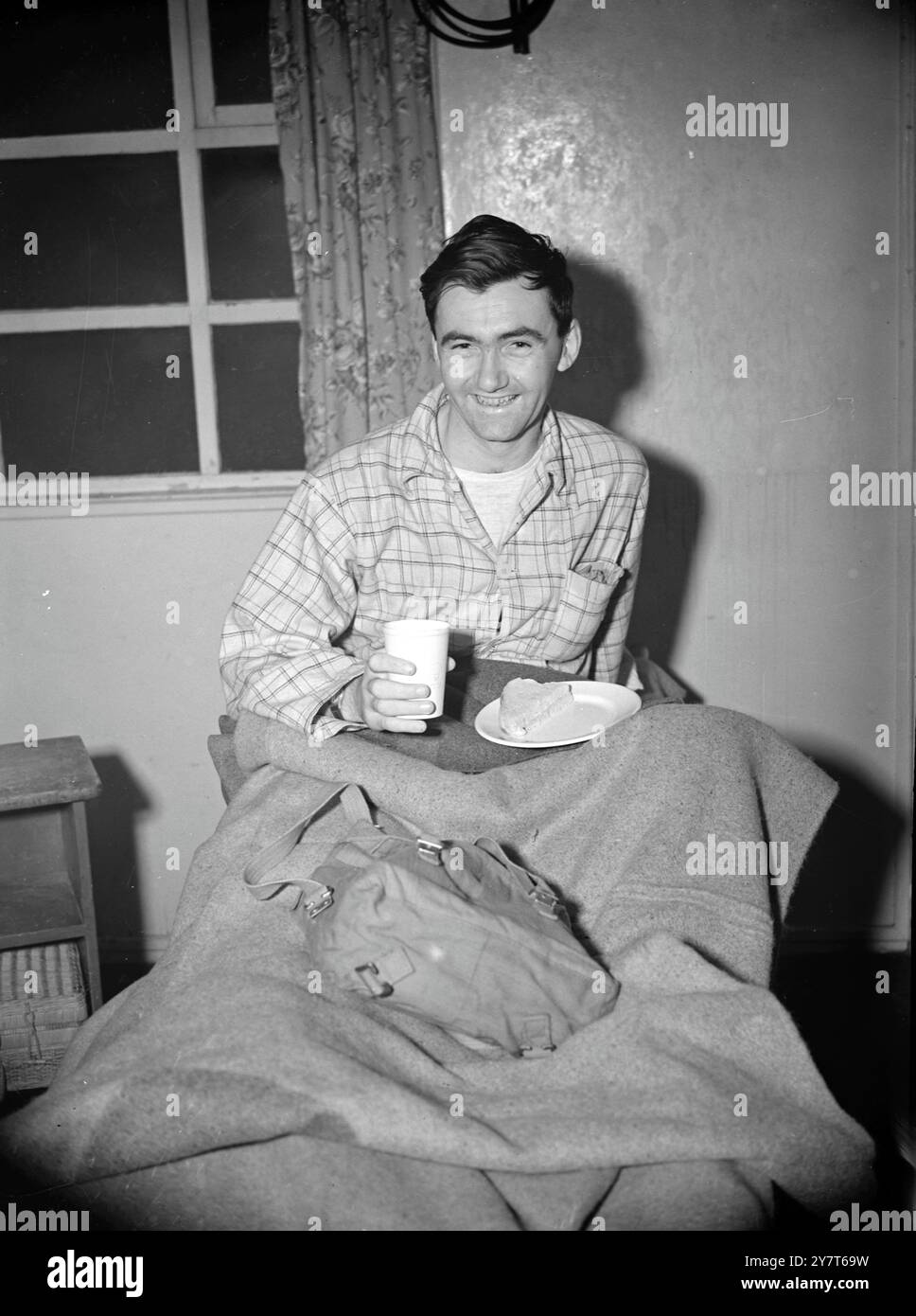 Der KOREANISCHE Korporal G. Potts vom Middlesex-Regiment genießt seinen ersten Snack in England nach der Ankunft mit dem Flugzeug, wo er Opfer der koreanischen Kämpfe und das Luftreinigungszentrum in Lyneham, Wiltshire, erlitten hat. Corporal Potts lebt in Ashford, Middlesex. 21 Opfer wurden rechtzeitig zu Weihnachten in England nach Hause geflogen. 16. Dezember 1950 Stockfoto