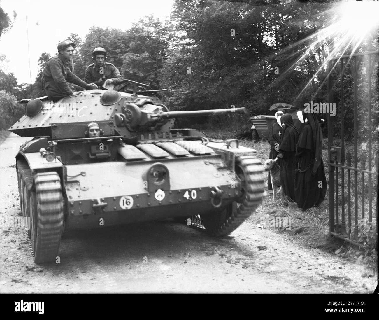 PANZER IM MANÖVER IN GROSSBRITANNIEN VORBEI AN NONNEN 1941 Ein Verteidiger kommt an einigen Nonnen vorbei. Mitglieder einer Panzerbesatzung halten auf einer Landstraße inne, um sich mit einer Gruppe von Nonnen zu unterhalten, um mit ihrem Hund spazieren zu gehen, während einer Pause bei Manövern in England Stockfoto