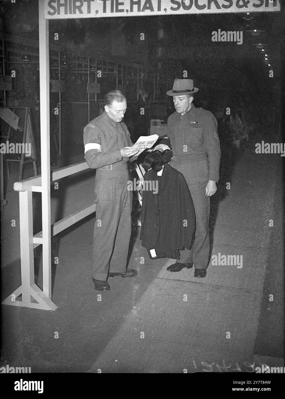 DEMOBILISIERUNGSKLEIDUNG FÜR DIE STREITKRÄFTE DEMONSTRIERTE IN LONDONNNder unter der Schirmherrschaft des Kriegsministeriums und des Versorgungsministeriums wurde in London eine Demonstration der Anzüge und Kleidung gegeben, die jedem Mitglied der Demobilisierungsstreitkräfte ausgestellt werden. Mit Männern der Royal Artillery als „Modelle“ waren Anzüge verschiedener Art und Farbe, Regenmäntel, Hemden, Schuhe, Socken und Krawatten zu sehen. FOTOSHOWS (3):- Ein Soldatenmodell, das während der Demonstration am 15. März 1944 seine Zivilkleidung aus dem Demobilisierungslager ausführt Stockfoto