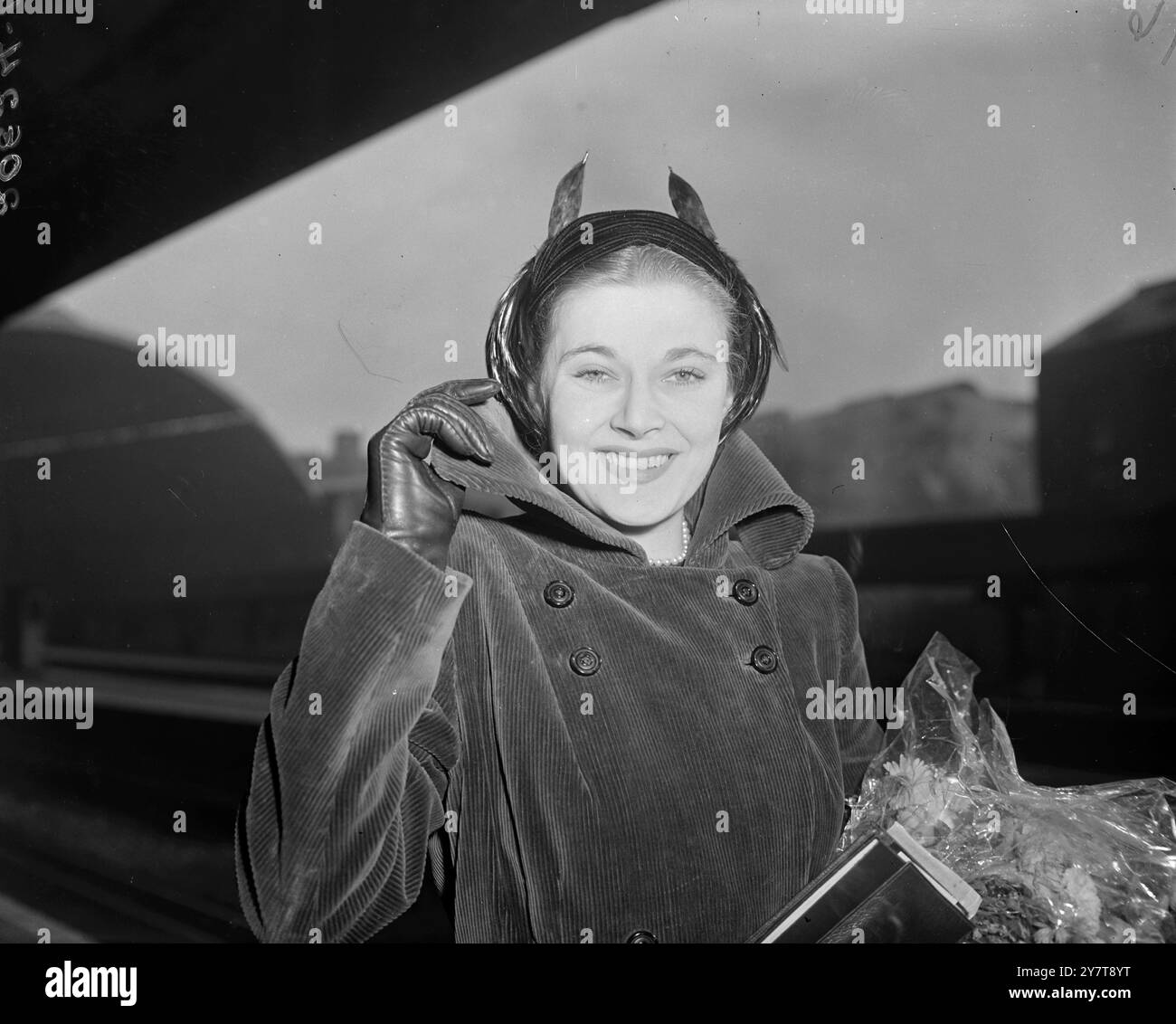 Die britische Filmschauspielerin HY HAZEL trägt einen Mantel mit hohem Kragen, als sie den Golden Arrow am Bahnhof Victoria, London, auf dem Weg nach Barcelona, bestieg. Miss Hazel, bekannt als " das Mädchen mit den längsten Beinen im Showbusiness ", wird im Kabarett in Spanien erscheinen. Nach ihrer Rückkehr nach Großbritannien -- in einem Monat -- um mit der Probe für Pantomime zu beginnen. 16. Oktober 1950 Stockfoto