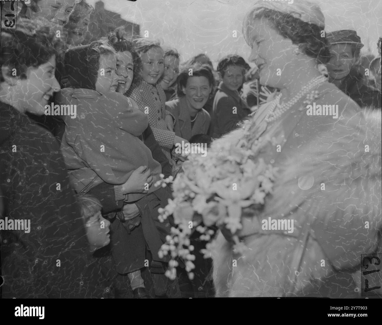 QUEEN MOTHER AT 10, WITHERSTON ROAD, LONDON LONDON: QUEEN ELIZABETH DIE QUEEN MUTTER SCHÜTTELT DIE HAND MIT DER 19-JÄHRIGEN STELLA COLE, BEOBACHTET VOM BÜRGERMEISTER VON WOOLWICH, ALDERMAN MRS. E. M. NEWMAN (RECHTS), WÄHREND EINES BESUCHS IM HAUS VON HERRN UND FRAU. FREDERICK COLE, 10 WITHERSTON ROAD, COLDHARBOUR HOUSING ESTATE, ELTHAM. HERR UND FRAU. COLES’ DREI WEITERE KINDER, MARTIN, 13 (LINKS), UND RICHARD, 12 UND ROBERT, 10, SIND EBENFALLS AUF DEM BILD. DIE KÖNIGSMUTTER BESUCHTE DIE GEMEINDE VON WOOLWICH'S COLDHARBOUR HOUSING ESTATE, UM SEINE FERTIGSTELLUNG ZU FEIERN, AM 9. MAI 1957 ZUSÄTZLICHES BILD - AUS EINEM SET VON 8 STÜCK Stockfoto