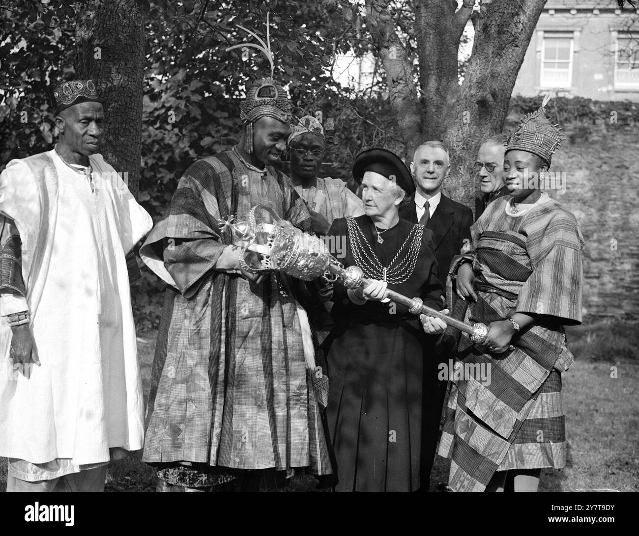 MACE UND MAJESTY Africans Zeichen der würde ist dann ein riesiger Schirm, aber der OBA ALAIYELUWA OLOGBEGI, Second Olowo of Owo, West Nigeria, interessiert sich genauso für das West-Insignia der bürgerlichen Führung - dieses massive Mace aus dem Jahr 1707, das ihm von Plymouth Lord Mayor Jacquetta Marshall gezeigt wurde. 25. Oktober 1950 Stockfoto