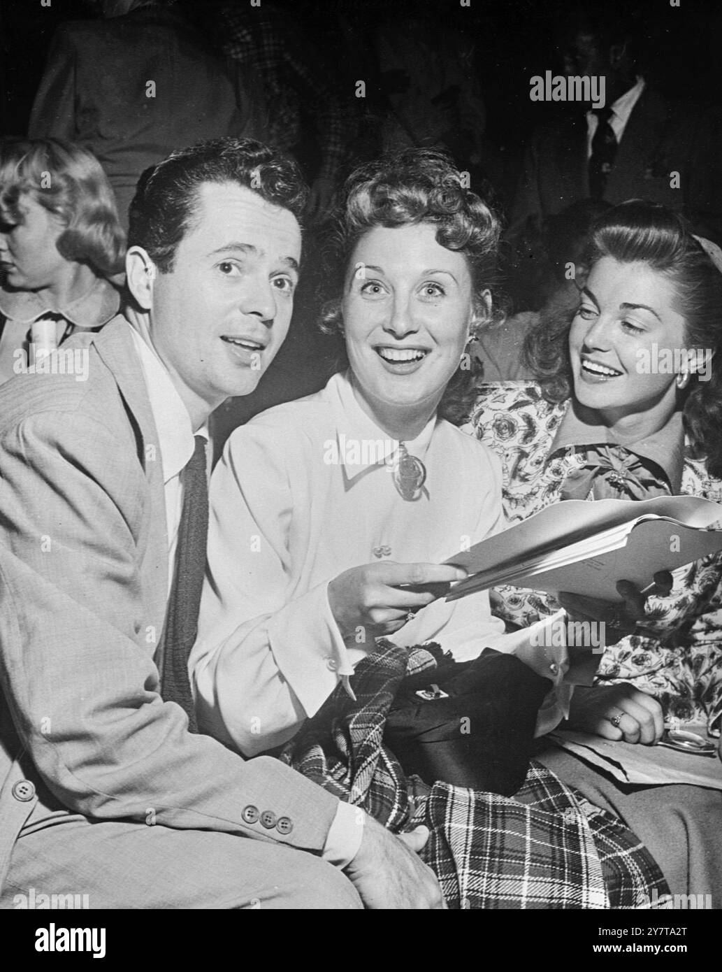 AM 23. Mai 1950 die Aufmerksamkeit abgelenkt, blickt Betty Garrett (Mitte) mit einem strahlenden Lächeln auf, während sie fotografiert wird, während sie dem Schauspieler Larry (Al Jolson) Parks und dem Schwimmstar Esther Williams in Hollywood Bilder zeigt. Stockfoto