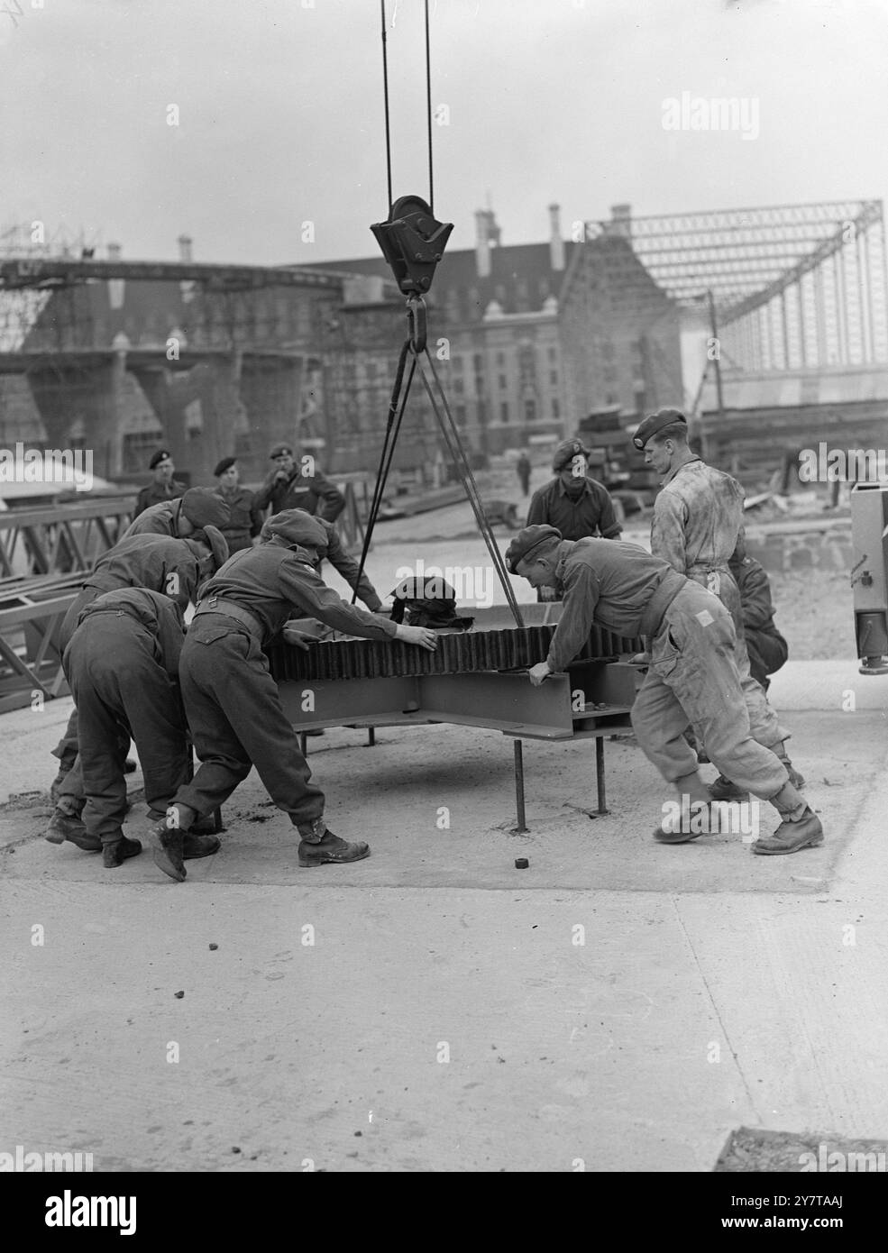 17. Mai 1950 Sappers vom 36th Army Engineer Regiment arbeiteten heute (Mittwoch) an den ersten Etappen der Bailey Bridge, die das Nord- und Südufer der Themse für die Ausstellung 1951 verbinden wird. Zuerst errichten sie ein riesiges Dampfderrick, 120 Meter hoch und etwa 80 Tonnen schwer, das die Errichtung der Bailey-Brücke bewältigen wird. Der Bohrturm hebt maximal sieben Tonnen Last in einem Abstand von 110 Fuß von seinem Drehzapfen. Die Bailey-Brücke wird nach Fertigstellung mehr als 600 Tonnen wiegen und 1150 Meter lang sein. Das wird es Stockfoto