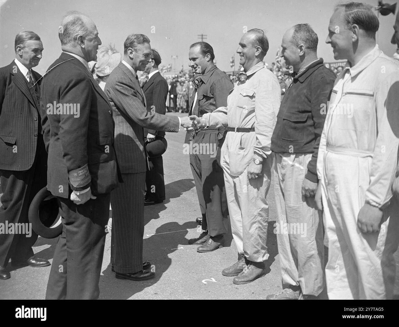 KING TRIFFT DIE FAHRER 13. Mai 1950 Eine Rekordmenge von über 150.000 Menschen, darunter der König und die Königin und Prinzessin Margaret, sah heute (Samstag) die erste Austragung des europäischen Grand-Prix-Rennens in diesem Land auf dem Silverstone-Flugplatz in Northants. Besonders beliebt war das italienische Team, darunter auch der Fahrer Reg Parnell aus Derby. Das Bild zeigt: Der König trifft heute vor dem Grand Prix in Silverstone auf Mitglieder der italienischen Mannschaft. Stockfoto