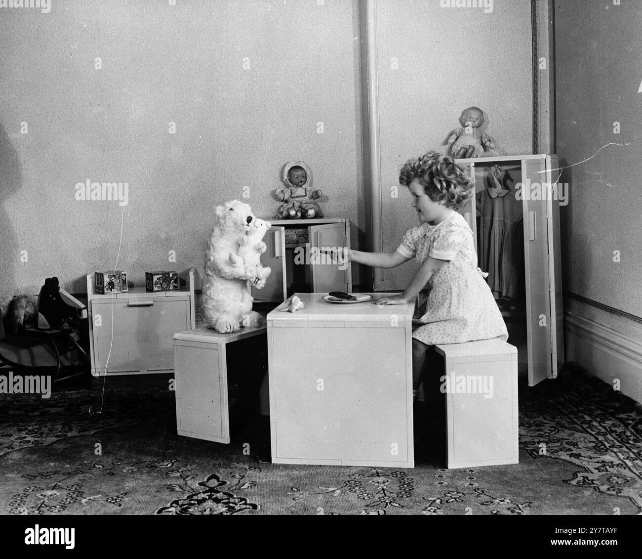 MODERNE SUITE die belästigte Hausfrau, die von Flecken und Kratzern auf ihren polierten Möbeln heimgesucht wird, beneidet die neueste Kinderzimmer-Suite, die zum ersten Mal gezeigt wird, wenn nächste Woche die British Industries Fair in Earls Court, London, eröffnet wird. Die sechsteilige Suite kann weder zerkratzt noch verbrannt oder fleckig werden, es gibt keine Schrauben oder Nägel, um ahnungslose Babyhände zu zerreißen, und Papa wird seine Beherrschung nicht verlieren, wenn er Werkzeuge und Kleber sucht, um sie zusammenzusetzen. Die Suite, die zu Hause leicht zusammengebaut wurde, passt dank der Stahlkanäle, die starr verriegelt sind, ordentlich und fest zusammen. Und wenn das Baby genug von ihrer Suite hat, dann ist es Stockfoto