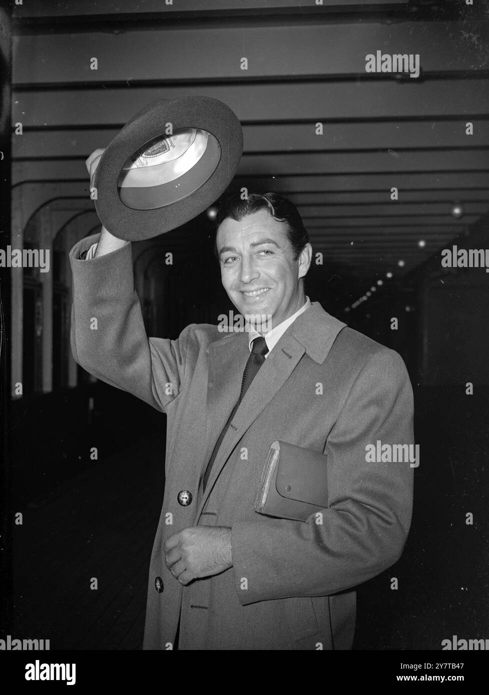 Am 28. April 1950 präsentiert der gutaussehende Filmschauspieler Robert Taylor eine neue Herrenmode mit einer Miniaktentasche unter dem Arm, als er an Bord der Cunard Liner Queen Mary aus New York nach Southampton kommt. Stockfoto