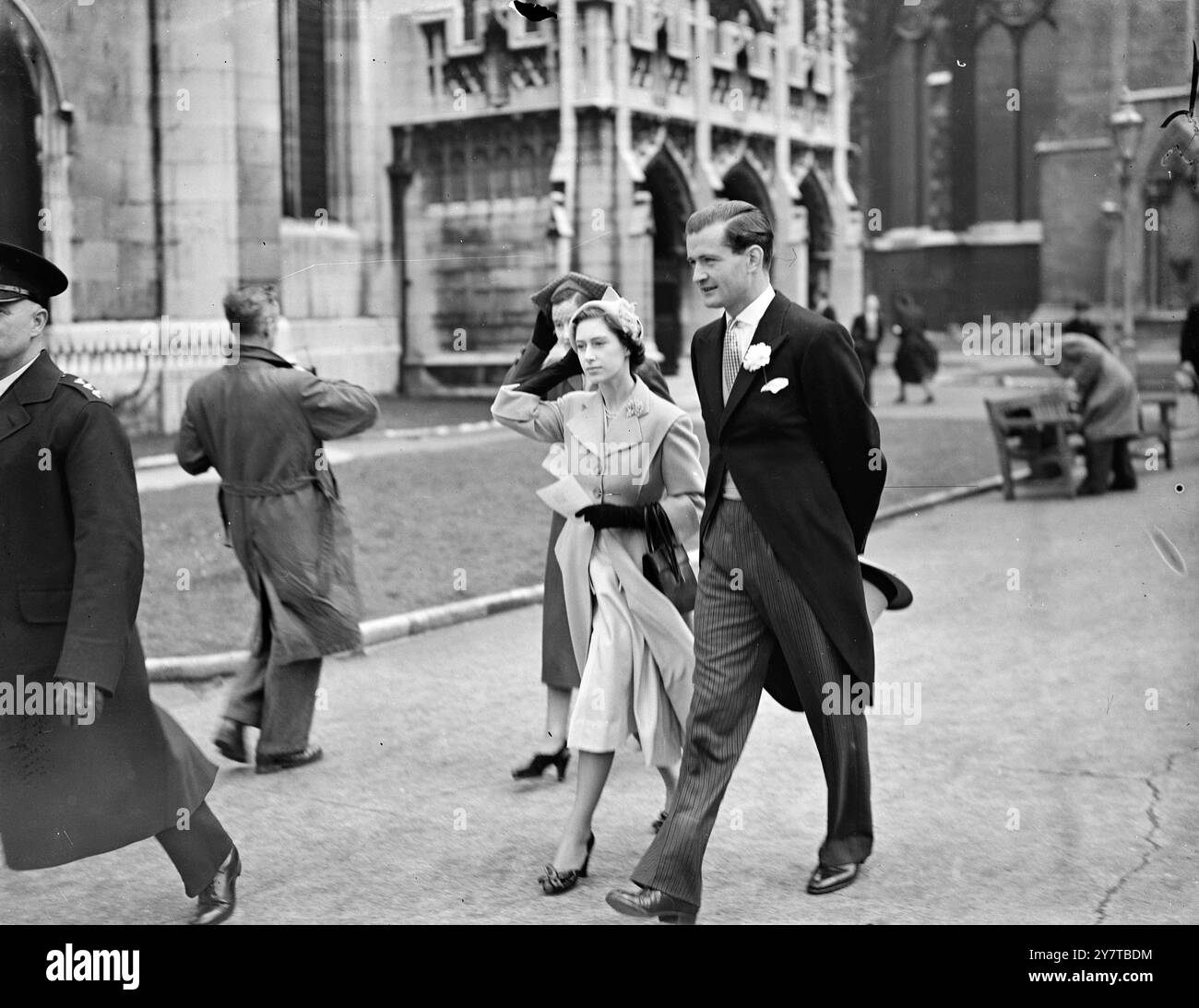 PRINZESSIN HÄLT IHREN HUT 19. April 1950 Prinzessin Margaret hält ihren Hut gegen eine Windböe, als sie heute (Mittwoch) die St. Margarets Church Westminster, London, verließ, nachdem sie an der Hochzeit von Miss Phillipa Dunne, der 19-jährigen Tochter von Captain Philip Dunne, mit Mr. Christopher Bridge teilgenommen hatte. Stockfoto