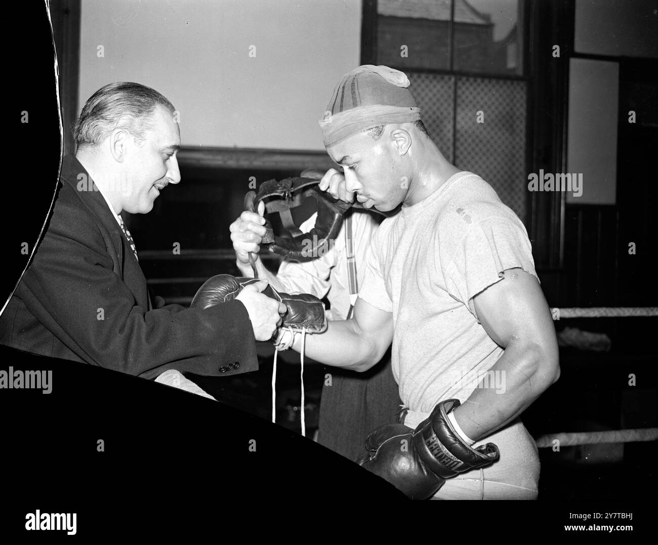 BOXER IN NYLON IST harte PRÜFUNG FÜR hart 14 April 1950 Training hart, praktisch ohne Sparringspartner, in Preston Park, Brighton, Sussex, ist Mel Brown, schwarze amerikanische Mittelwicht aus St. Paul, Minnessota. Am kommenden dienstag (18. April) trifft er auf Mark Hart aus Croydon, einen führenden Anwärter um den Titel im Schwergewicht British Light, über 10 Runden bei 12 Stein9 Pfund am Streatham (London) Ice Rink. Browns Ruf als harter Schläger, der sich für mehrere amerikanische Titelkämpfer als Scherz erwiesen hat, ist so hoch, dass die lokalen Mittelgewichte nur zögerlich mit ihm in Brighton zu kämpfen haben. Hart gilt als ta Stockfoto