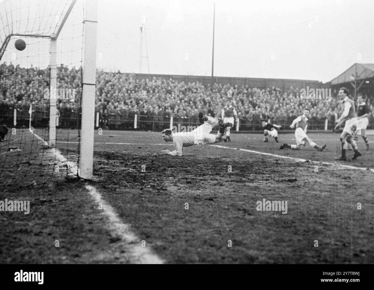 RAITH ROVERS GEWINNT DAS POKALSPIEL Kirkcaldy, Schottland: Raith Rovers Mittelstürmer Ernie Copland besiegt zum zweiten Mal den Hibernischen Torwart Tommy Younger und gibt seinem Team das zweite Tor. Raith Rovers gewann das Scottish Cup Replay Match mit 3:1. 14. Februar 1956 Stockfoto