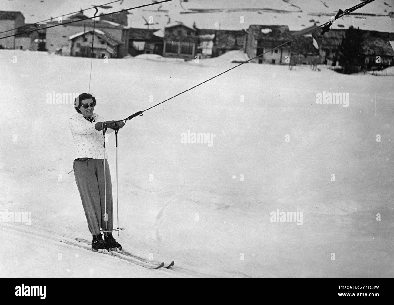 AM 4. April 1950 hält die Königin Juliana von den Niederlanden an, die am Skilift im Val d'Isere, Südostfrankreich, zu sehen ist. Die Königin genießt einen Alpenurlaub mit Prinz Bernhard und ihren beiden älteren Töchtern, Prinzessinnen Beatrix und Irene. Stockfoto