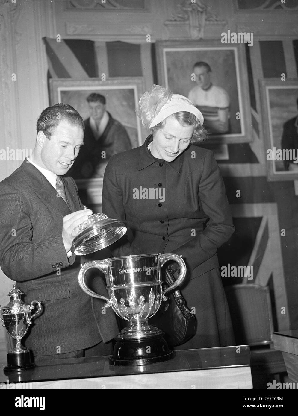 Reg Harris, der als erster Radrennfahrer Britians " Sportsman des Jahres " gewählt wurde, zeigt den Pokal an Fanny Blankers-Koen Hollands Star-Olympiasiegerin bei der Verleihung im Savoy Hotel in London heute Abend. Harris, Profi-Sprint-Champion der Welt, gewann den Titel und die Trophäe mit einer Mehrheit von fast 7.000 Stimmen gegen Billy Liddell, Liverpool-Fußballspieler, in der Jahresumfrage „Sporting Record“ vom 29. März 1950 Stockfoto